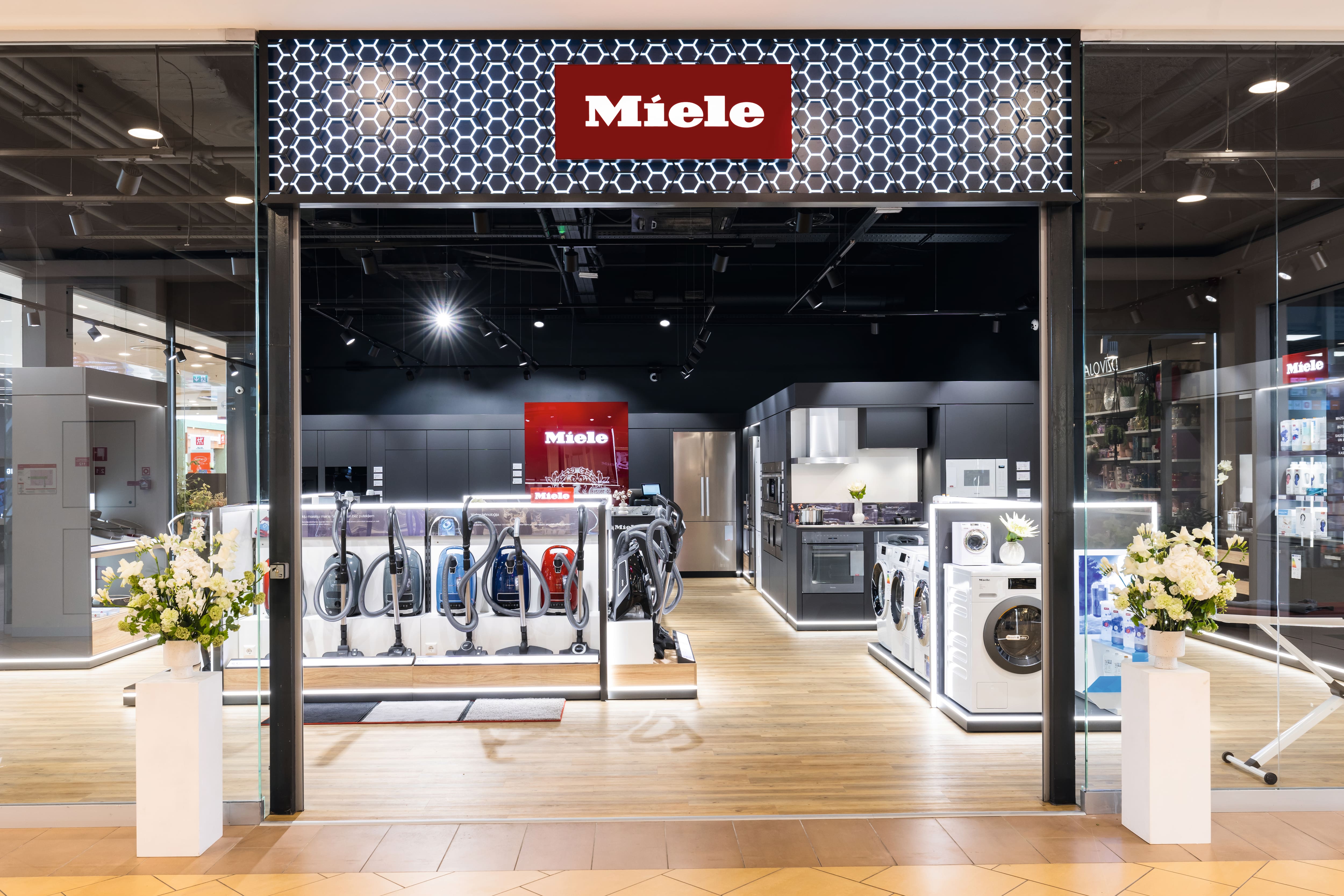 Mūsdienīgs Miele veikals ar putekļsūcējiem un veļas mašīnām, elegantu apgaismojumu un virtuves demonstrācijām. Mūsdienīgs Miele veikals ar putekļsūcējiem un veļas mašīnām, elegantu apgaismojumu un virtuves demonstrācijām.
