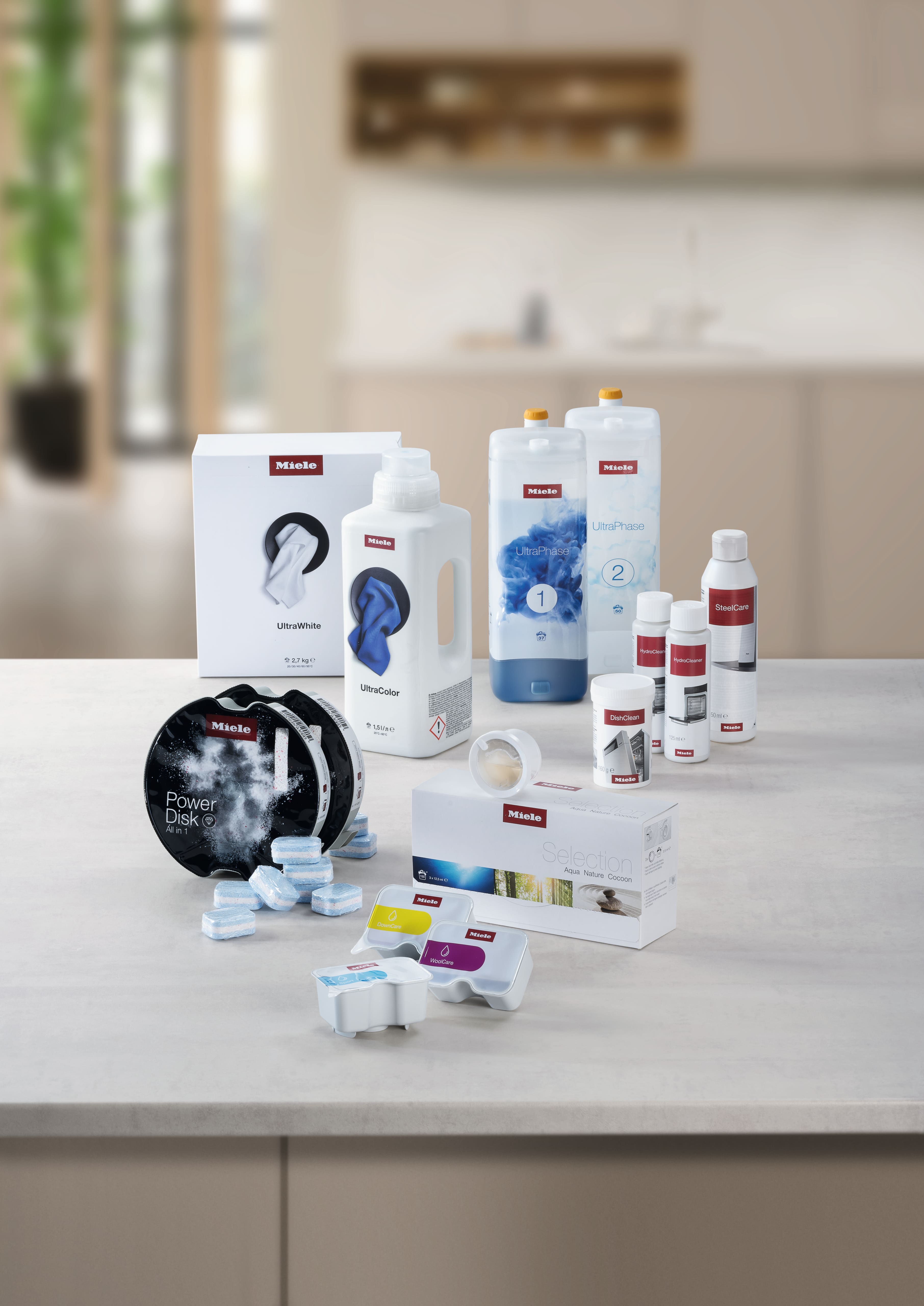 Verschiedene Miele Waschmittel und Pflegeprodukte auf einer Theke, die Wasch- und Spülmittel präsentieren.