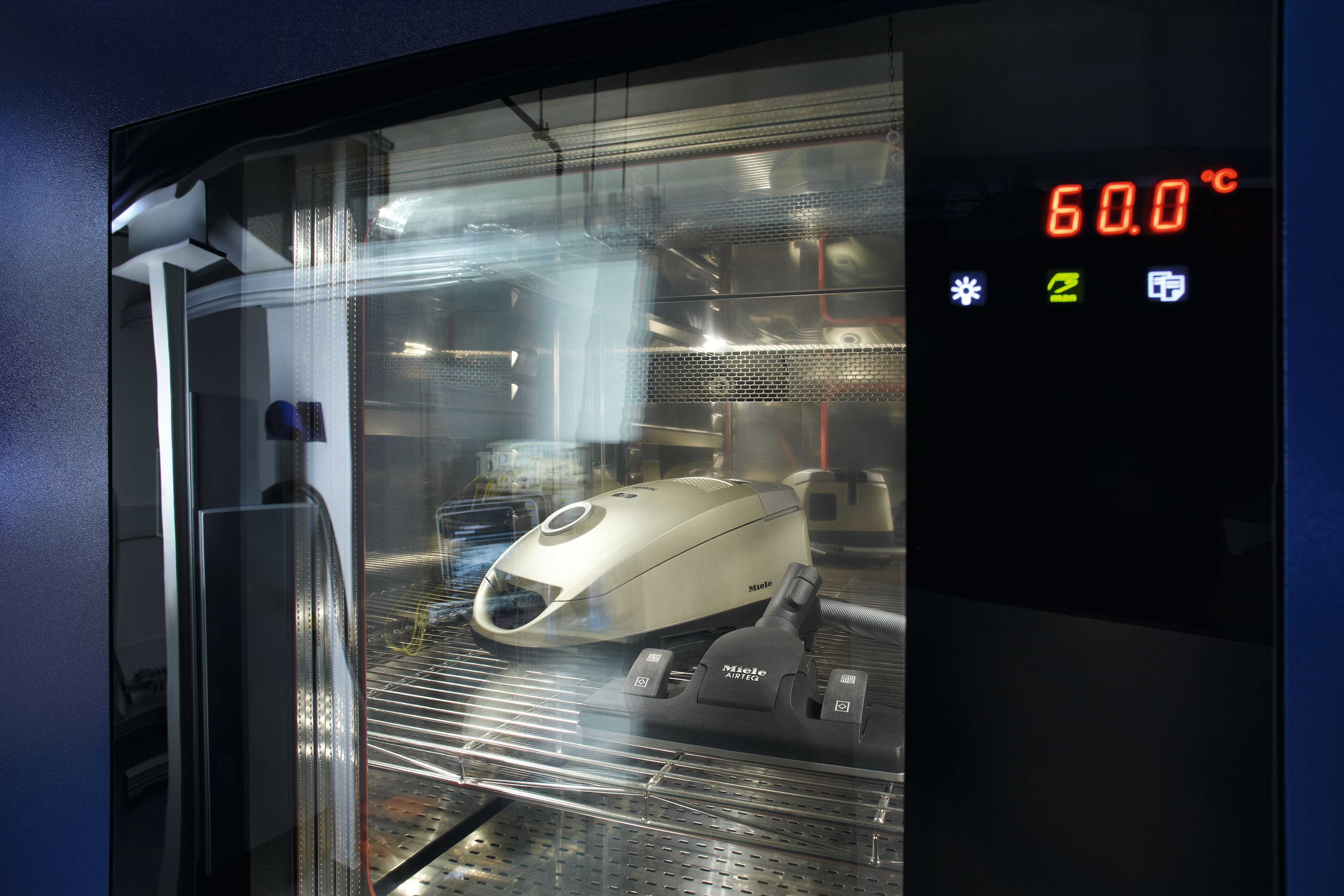 A vacuum cleaner inside a turned on oven - showing 60° C A vacuum cleaner inside a turned on oven - showing 60° C