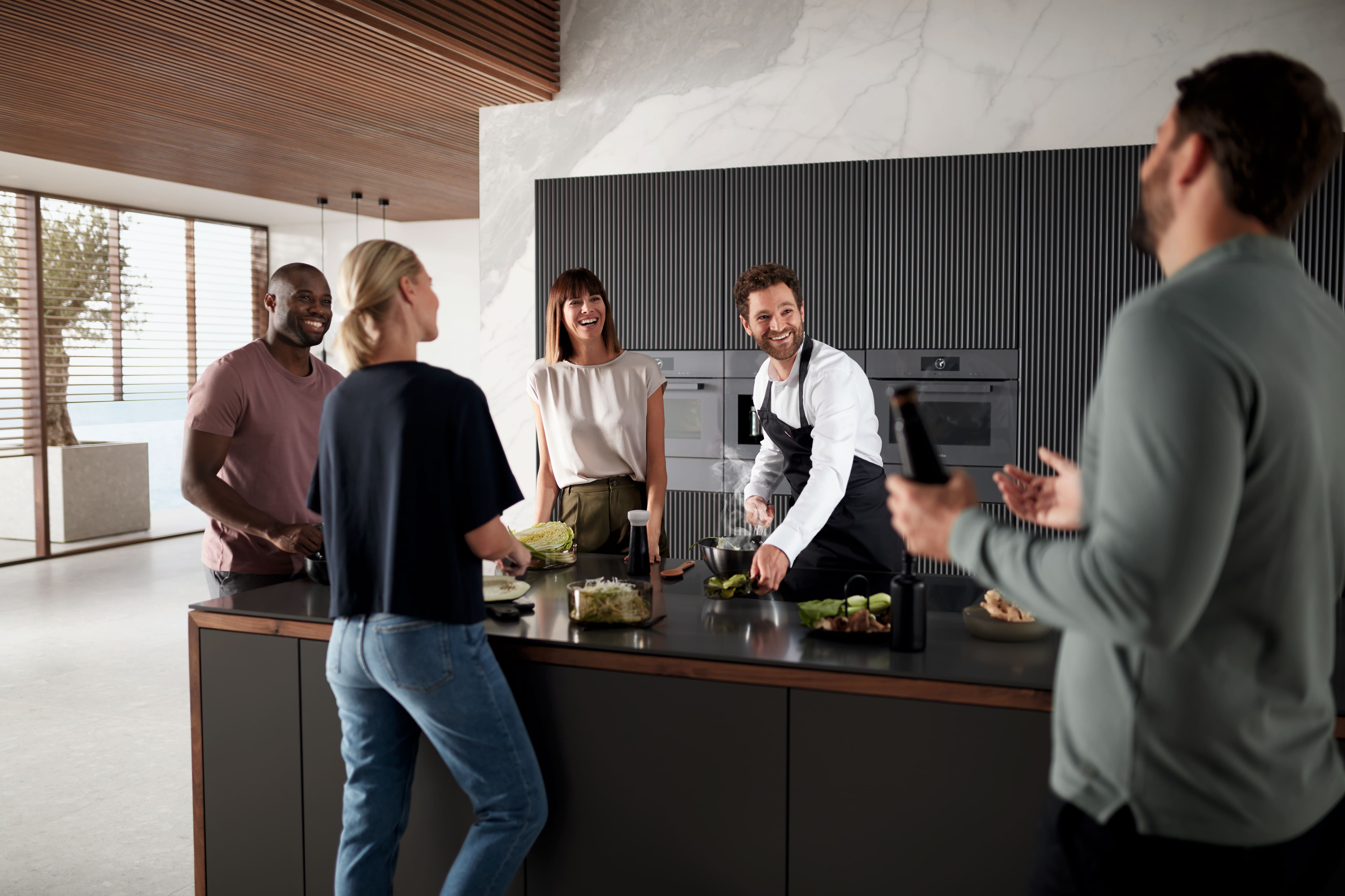 A group of persons cooking together in a kitchen