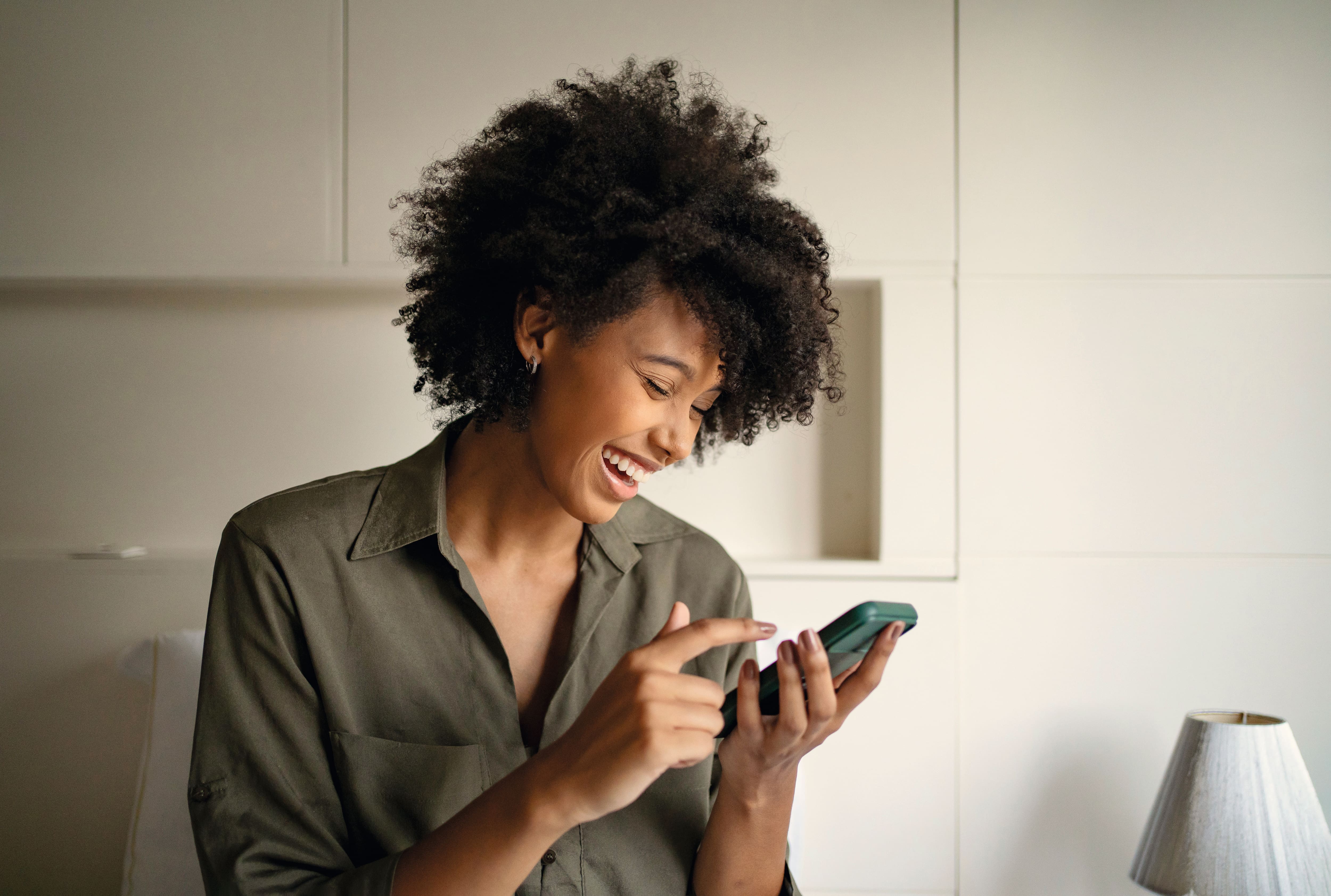 woman laughing and looking at her phone