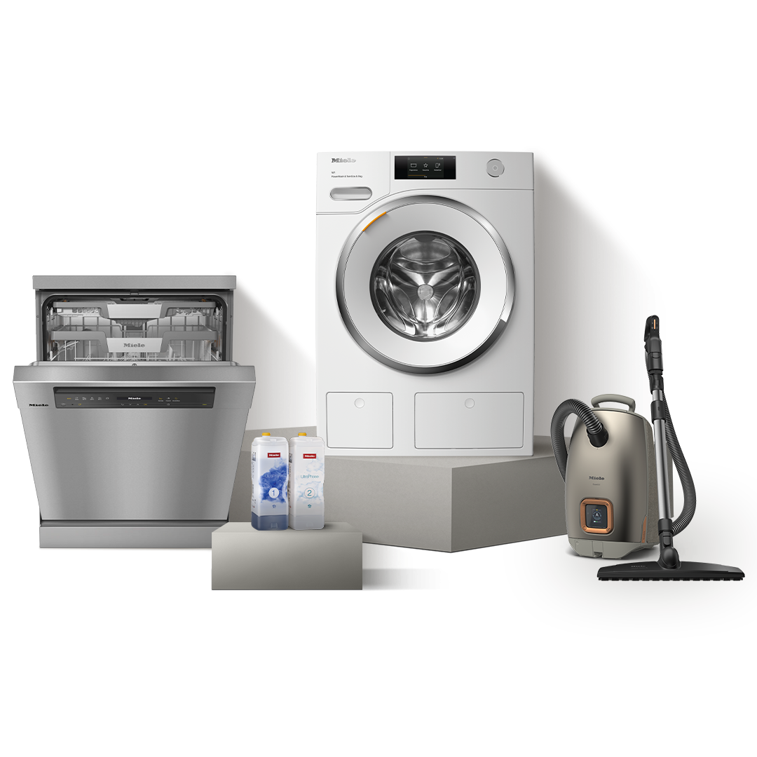 Front-load washer flanked by coffee machine and cordless stick vacuum, wrapped by a dark green ribbon. Front-load washer flanked by coffee machine and cordless stick vacuum, wrapped by a dark green ribbon.