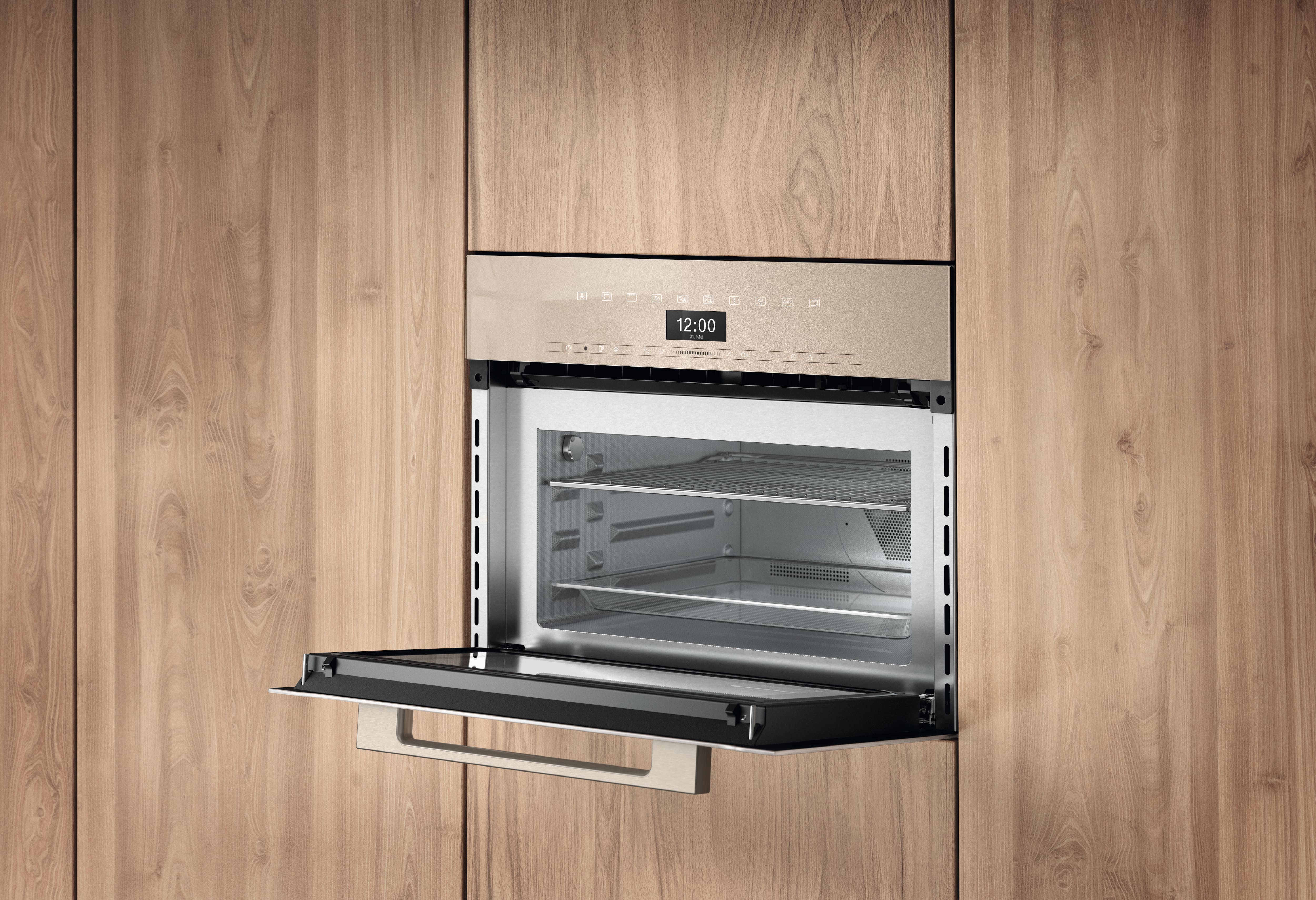 Built-in stainless steel oven integrated into wooden cabinetry, door open downward, showing interior racks and a digital control panel displaying 12:00. Built-in stainless steel oven integrated into wooden cabinetry, door open downward, showing interior racks and a digital control panel displaying 12:00.