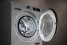 Front-loading washing machine with door open, showing stainless steel drum and control panel; parts shown separately.