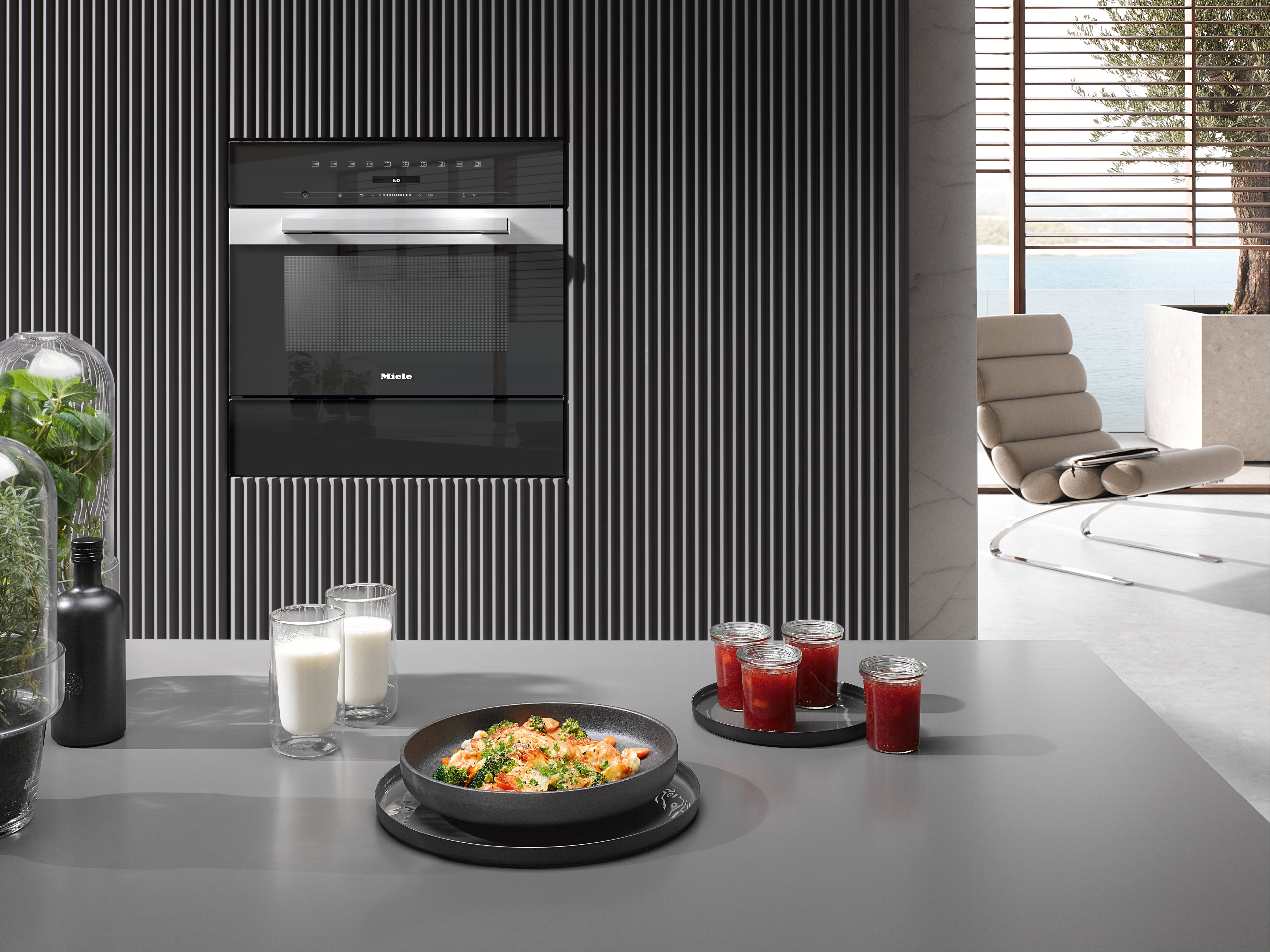 Miele microwave oven on the background with dish on counter Miele microwave oven on the background with dish on counter