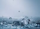 Close-up of clear water splashing with droplets suspended in midair, conveying freshness and purity.