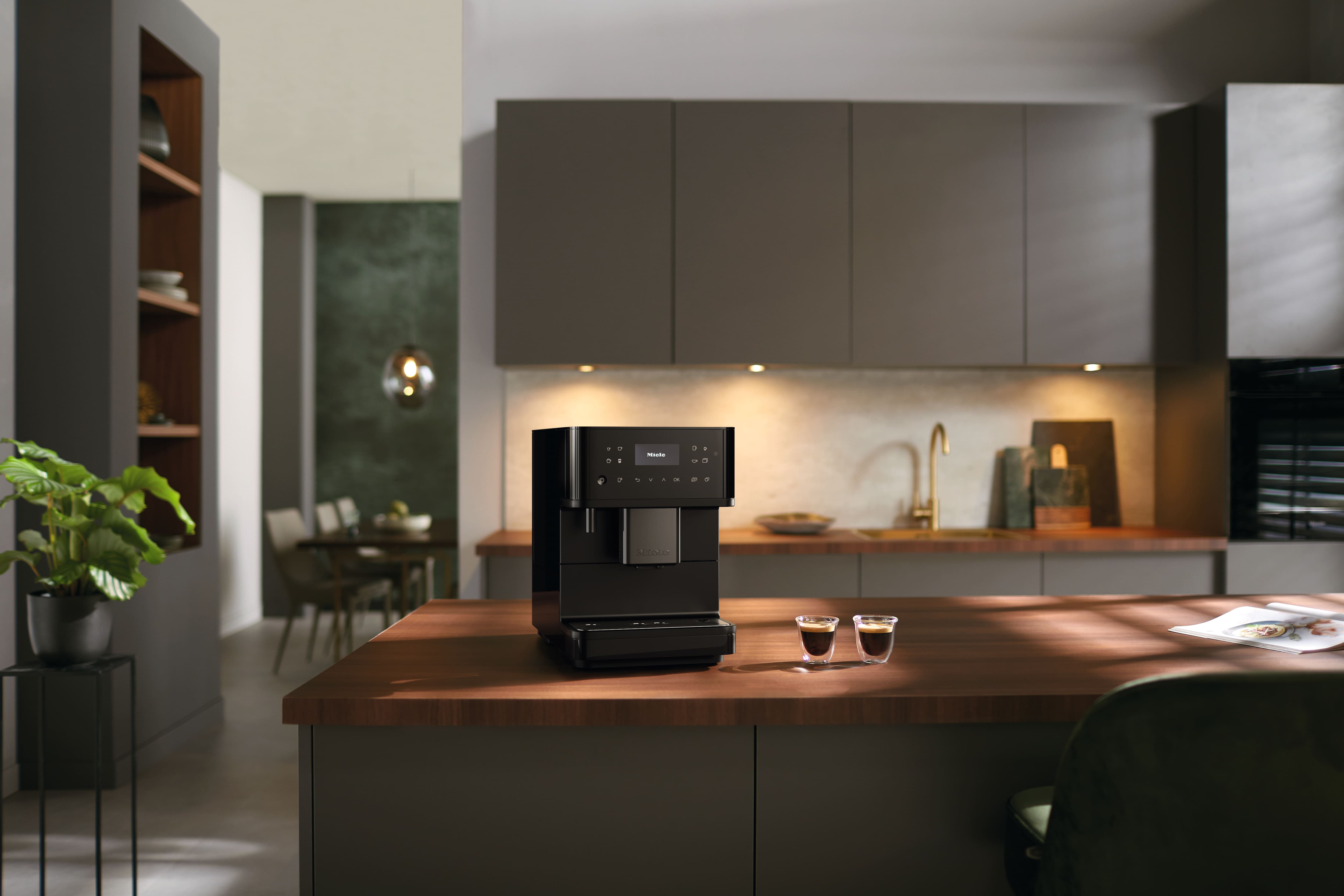 Miele Kaffeevollautomat auf einer modernen Kücheninsel in einer hellen Wohnküche.