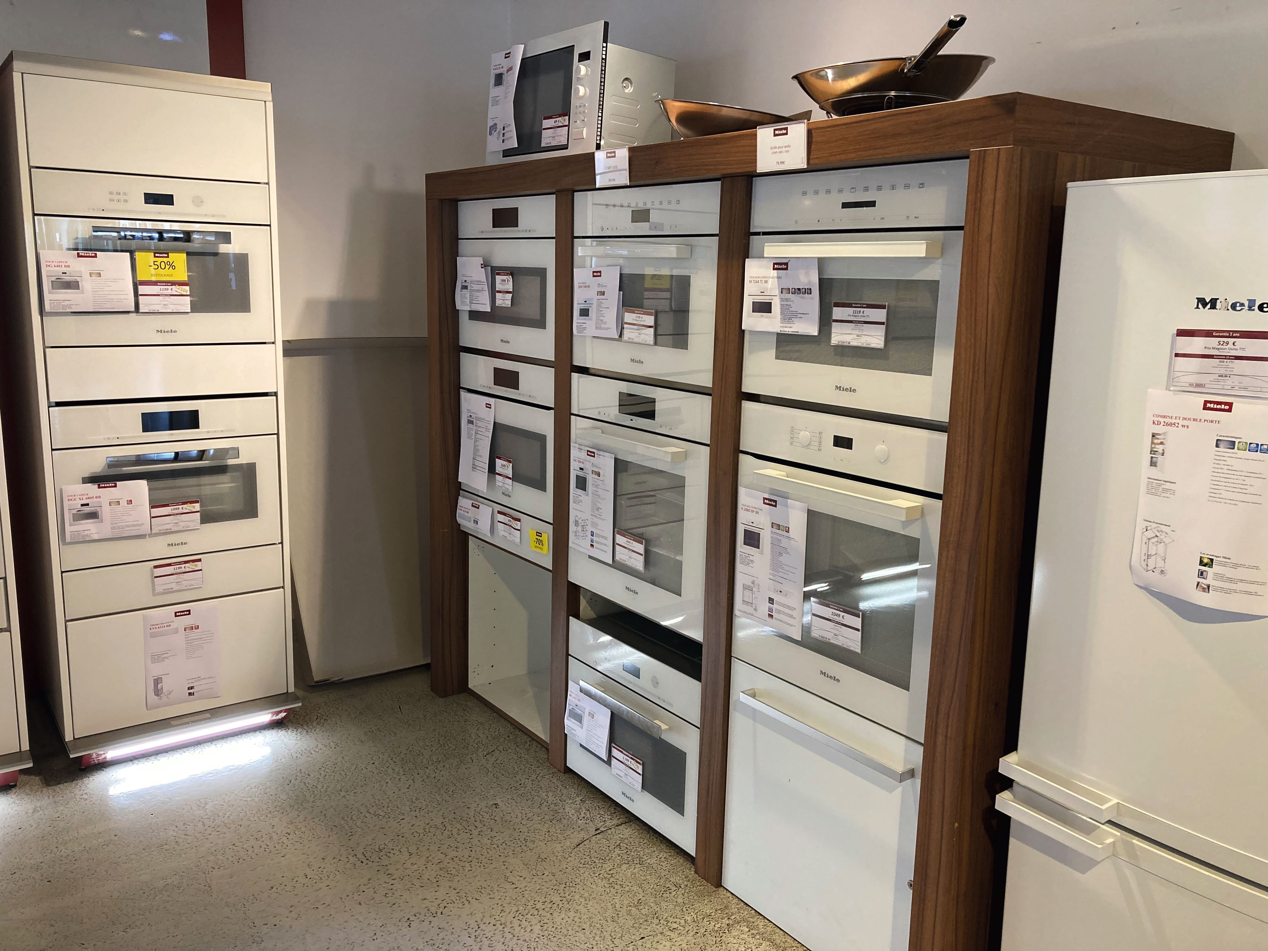 Ausstellung von Haushaltsgeräten mit mehreren Miele Einbauöfen und Mikrowellen, Preisschilder an den Türen. Ausstellung von Haushaltsgeräten mit mehreren Miele Einbauöfen und Mikrowellen, Preisschilder an den Türen.