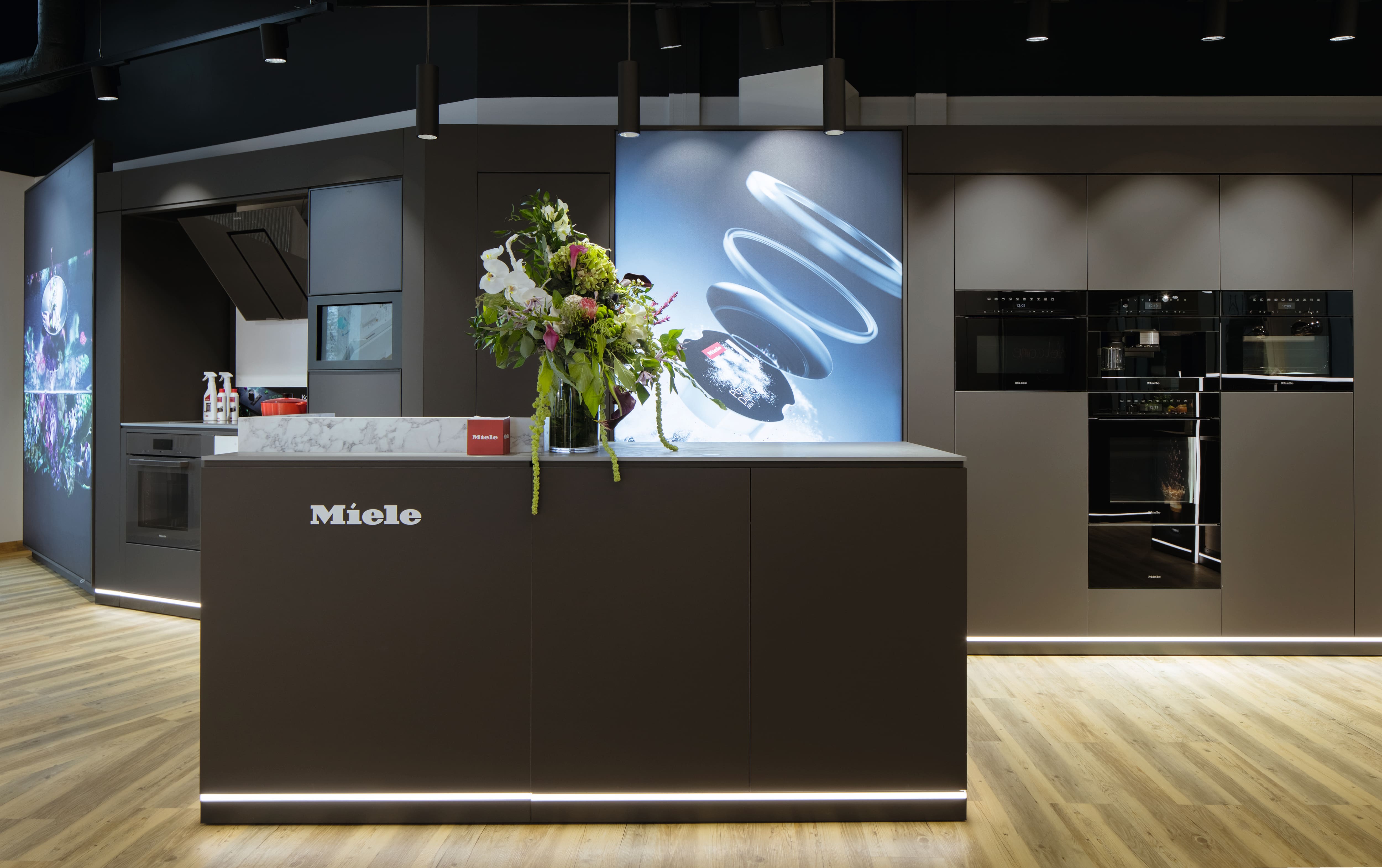 Kontuar w salonie Miele Experiece Center i urządzenia Miele w zabudowie za kontuarem