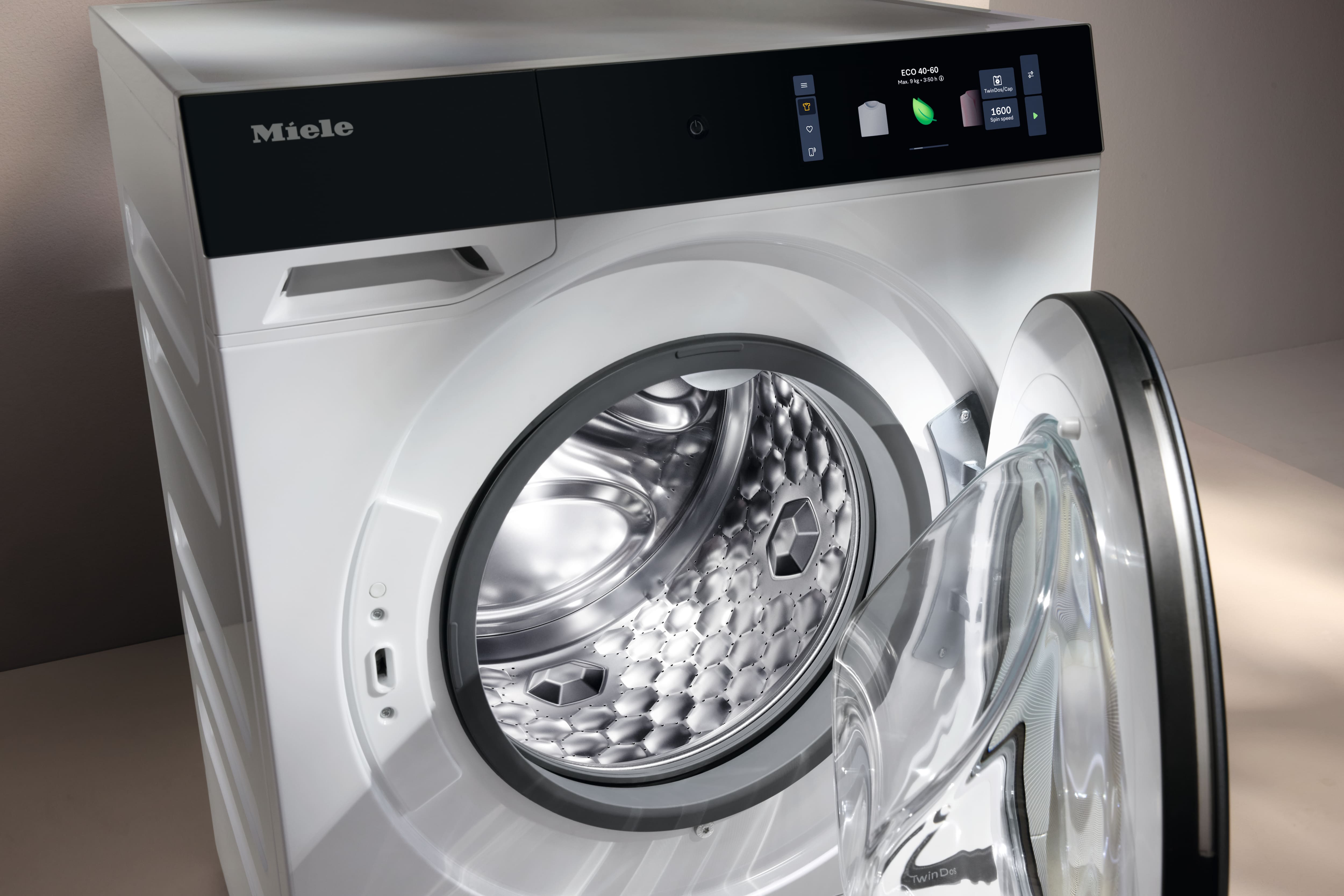 Lavatrice Miele a carica frontale con oblò in vetro aperto, cestello in acciaio inox illuminato e display digitale Eco. Lavatrice Miele a carica frontale con oblò in vetro aperto, cestello in acciaio inox illuminato e display digitale Eco.