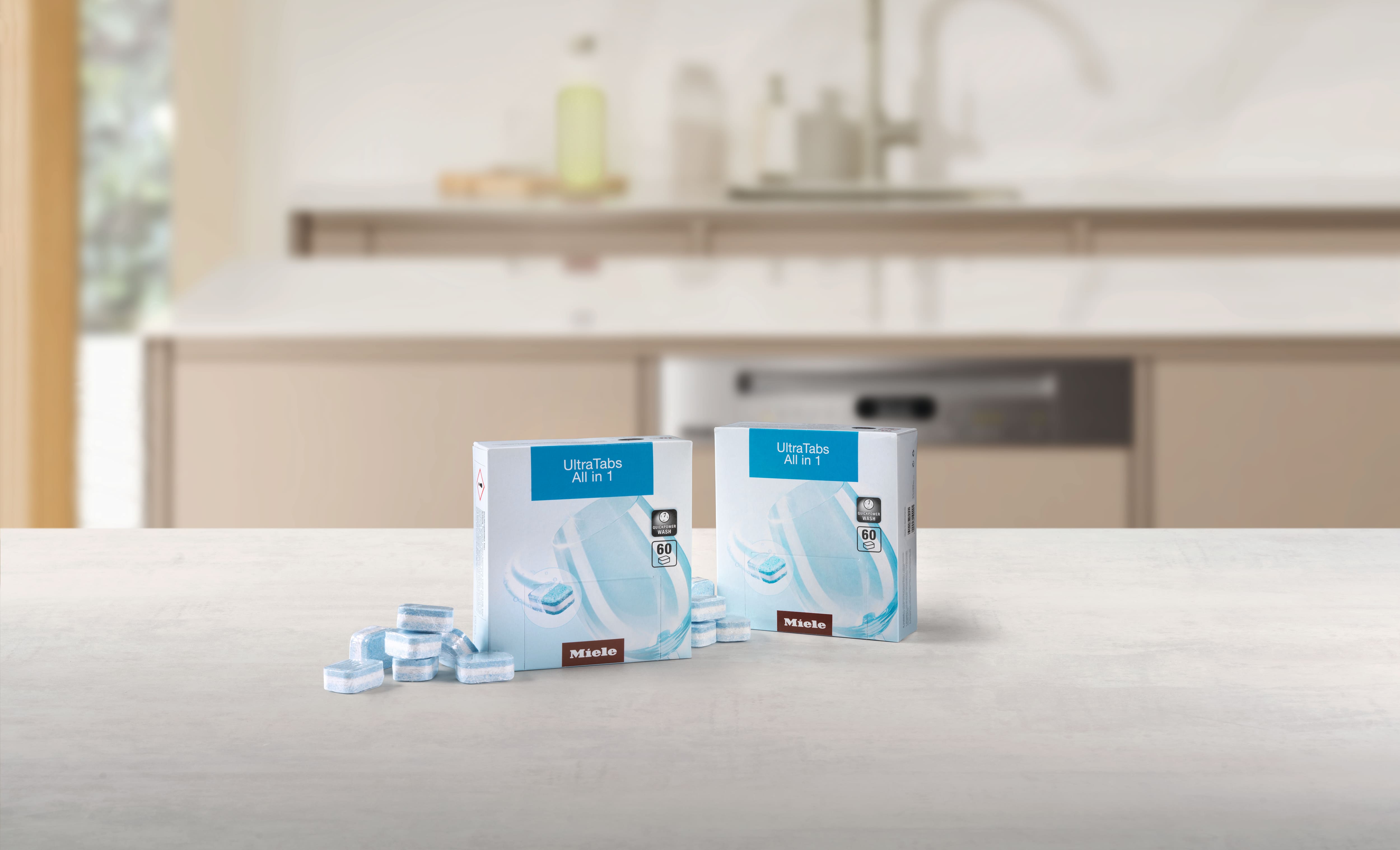 Two boxes of Miele UltraTabs All in 1 dishwasher tablets with loose blue tabs, highlighting product packaging. Two boxes of Miele UltraTabs All in 1 dishwasher tablets with loose blue tabs, highlighting product packaging.