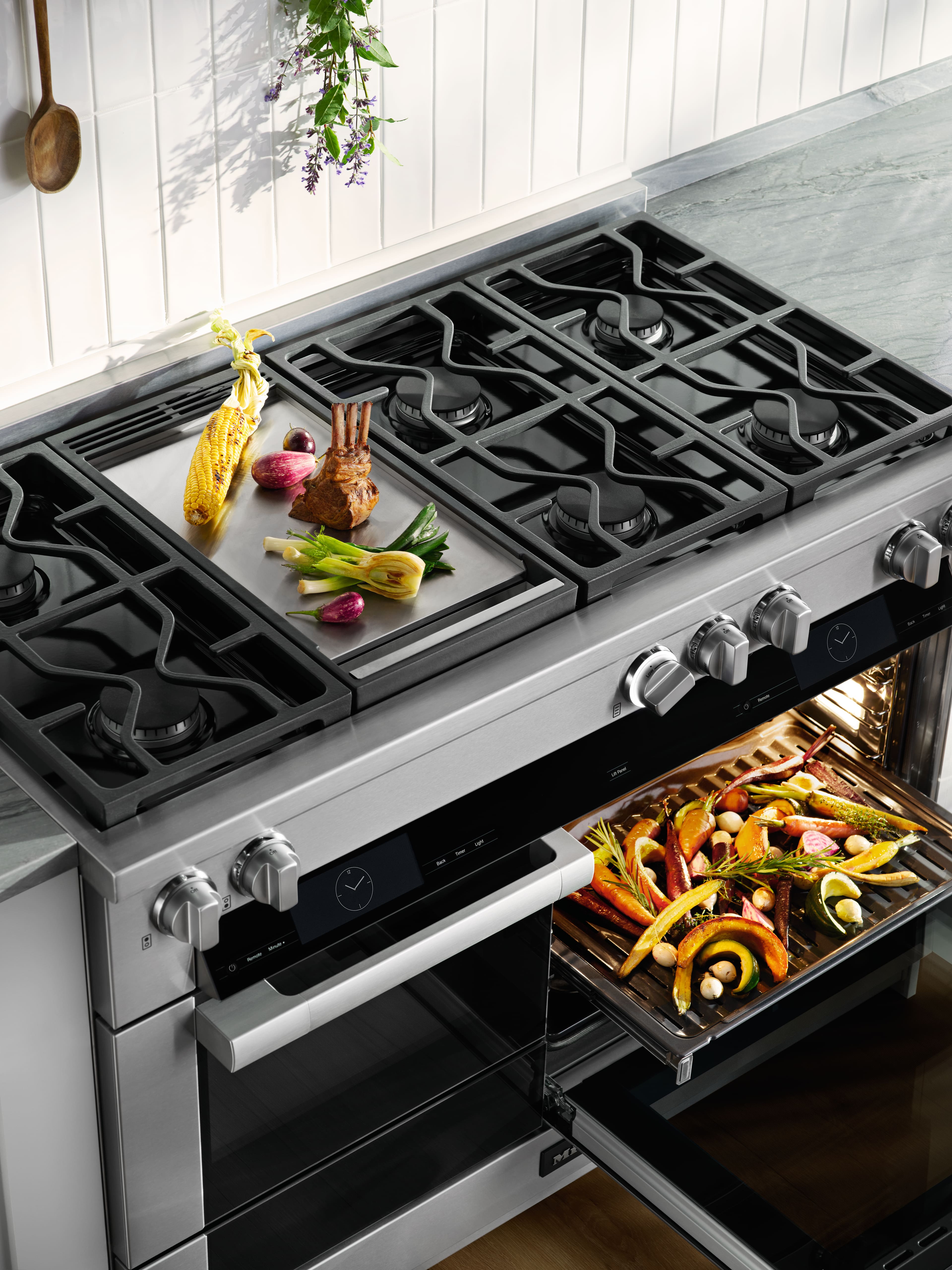 Modern stainless steel gas range with six burners and griddle; oven roasting colorful vegetables. Modern stainless steel gas range with six burners and griddle; oven roasting colorful vegetables.
