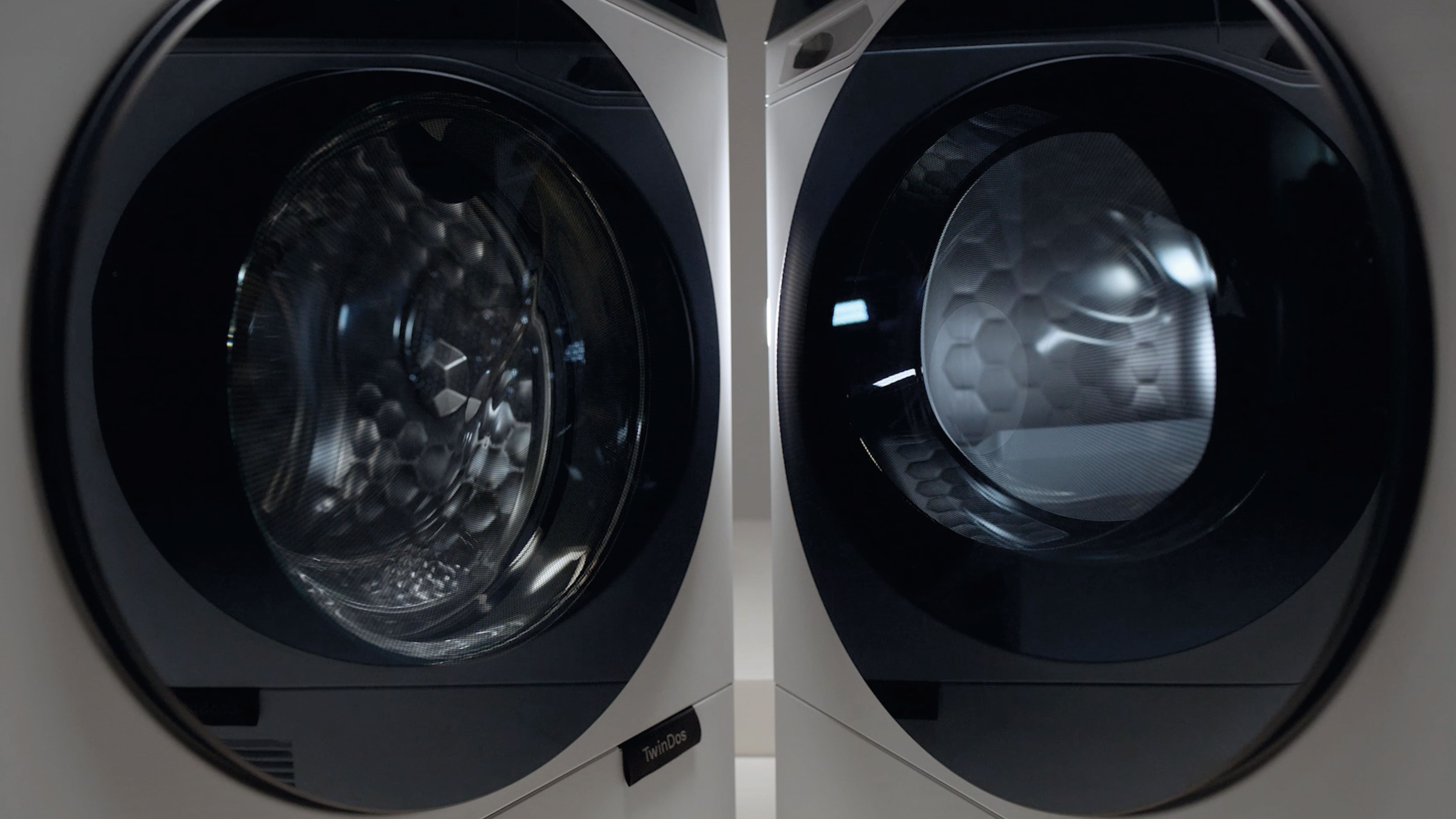 Close-up of two Miele modern front-loading laundry machines side by side, highlighting sleek doors and drum design. Close-up of two Miele modern front-loading laundry machines side by side, highlighting sleek doors and drum design.