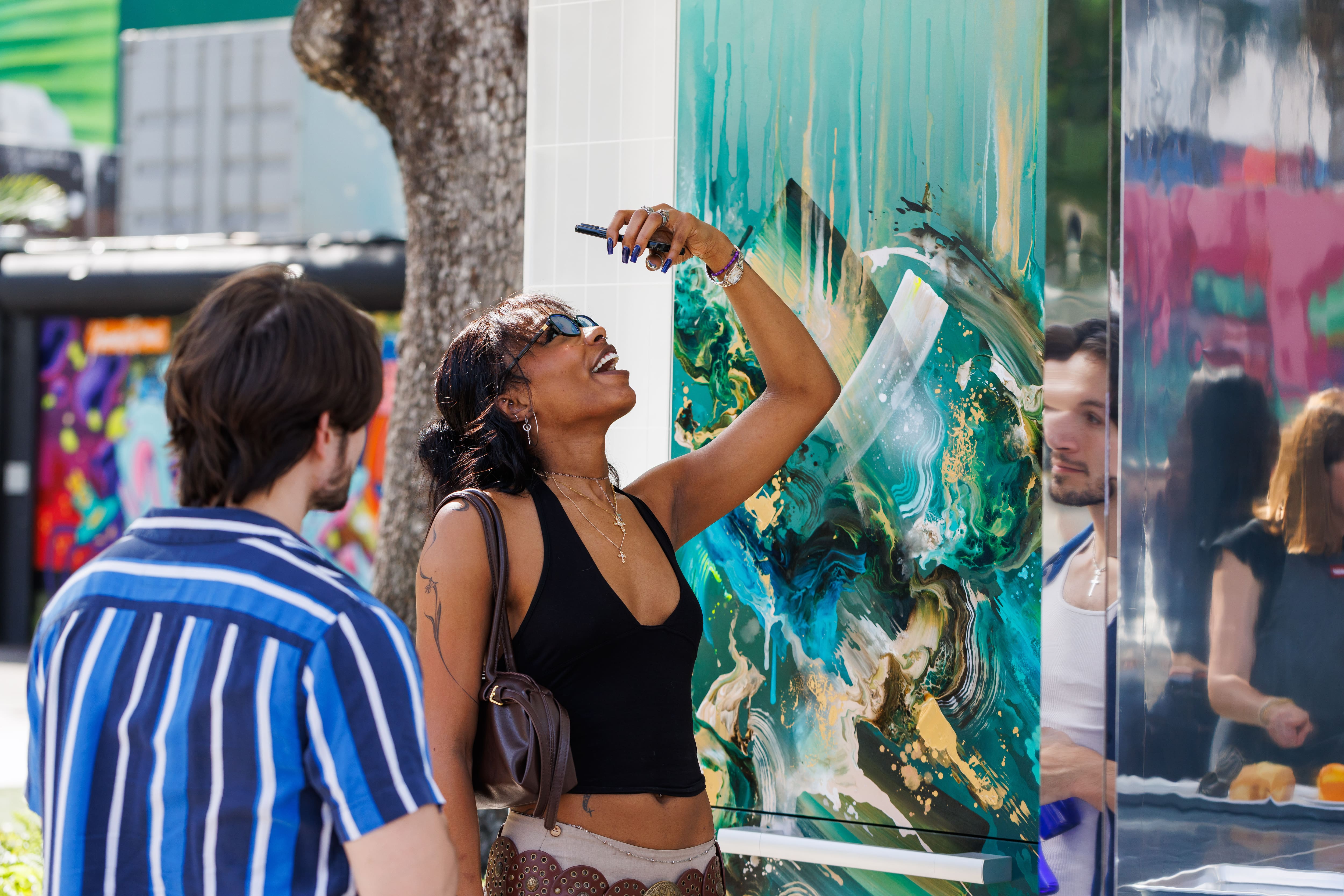Guest explores The Kitchen Muse by Miele at Wynwood Walls, interacting with a colorful abstract art installation that blends contemporary art, design, and kitchen innovation. Guest explores The Kitchen Muse by Miele at Wynwood Walls, interacting with a colorful abstract art installation that blends contemporary art, design, and kitchen innovation.