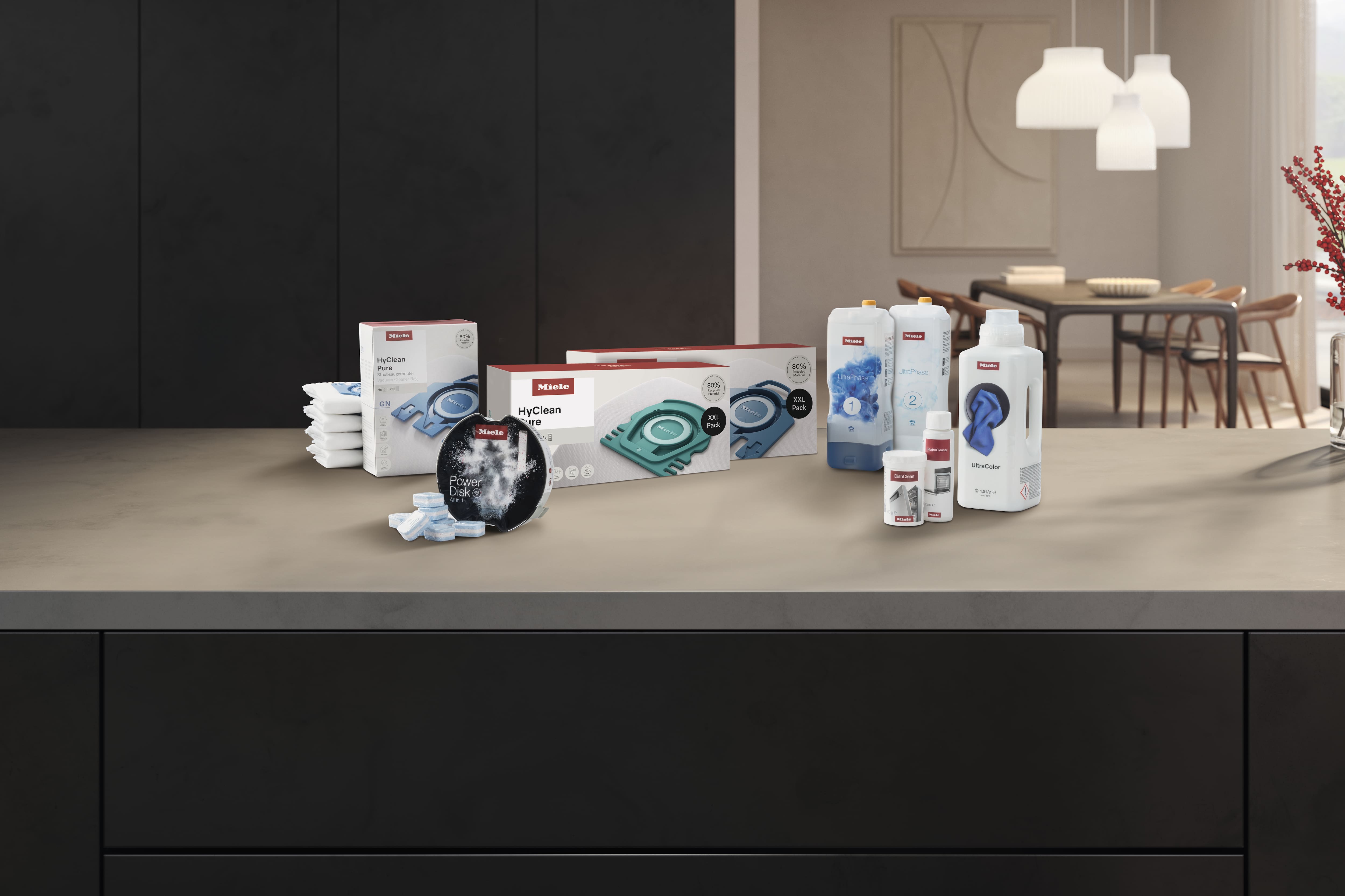 Assortiment de produits d'entretien et de soin Miele présentés sur un plan de travail de cuisine moderne dédié aux appareils électroménagers.