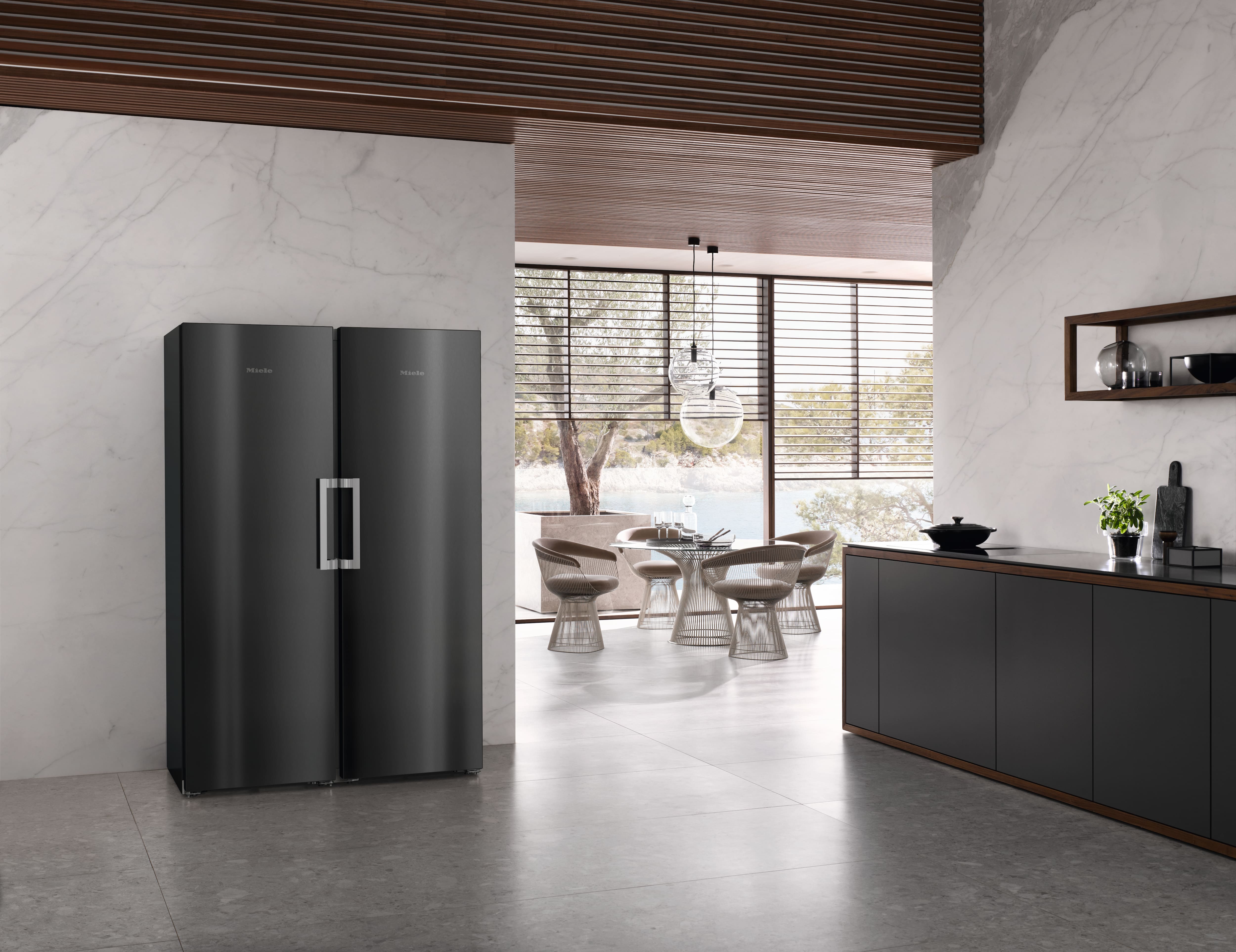 Modern kitchen with dark matte double-door fridge, marble walls, sleek cabinets Modern kitchen with dark matte double-door fridge, marble walls, sleek cabinets