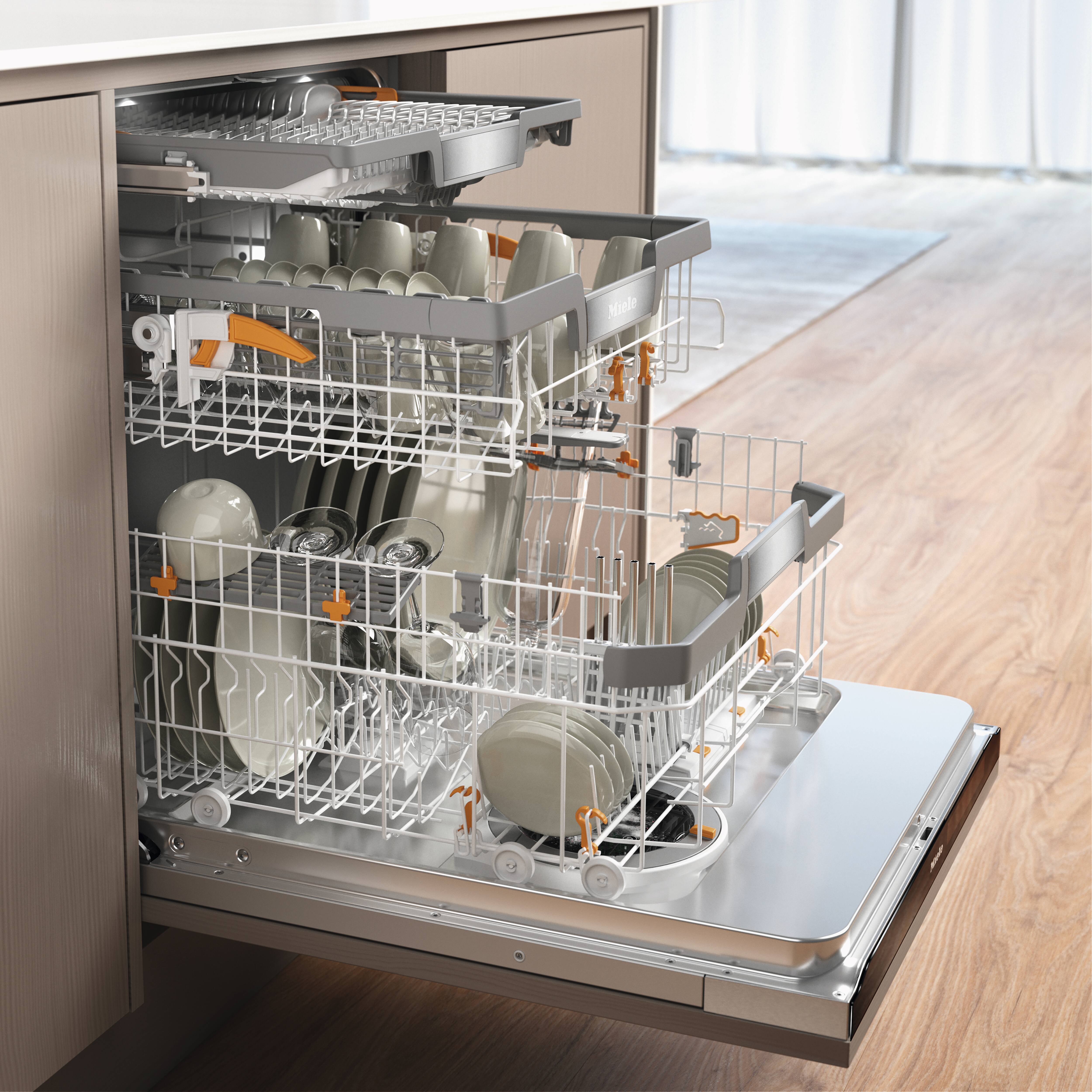 Uma máquina de lavar louça Miele aberta, com pratos limpos dentro Uma máquina de lavar louça Miele aberta, com pratos limpos dentro