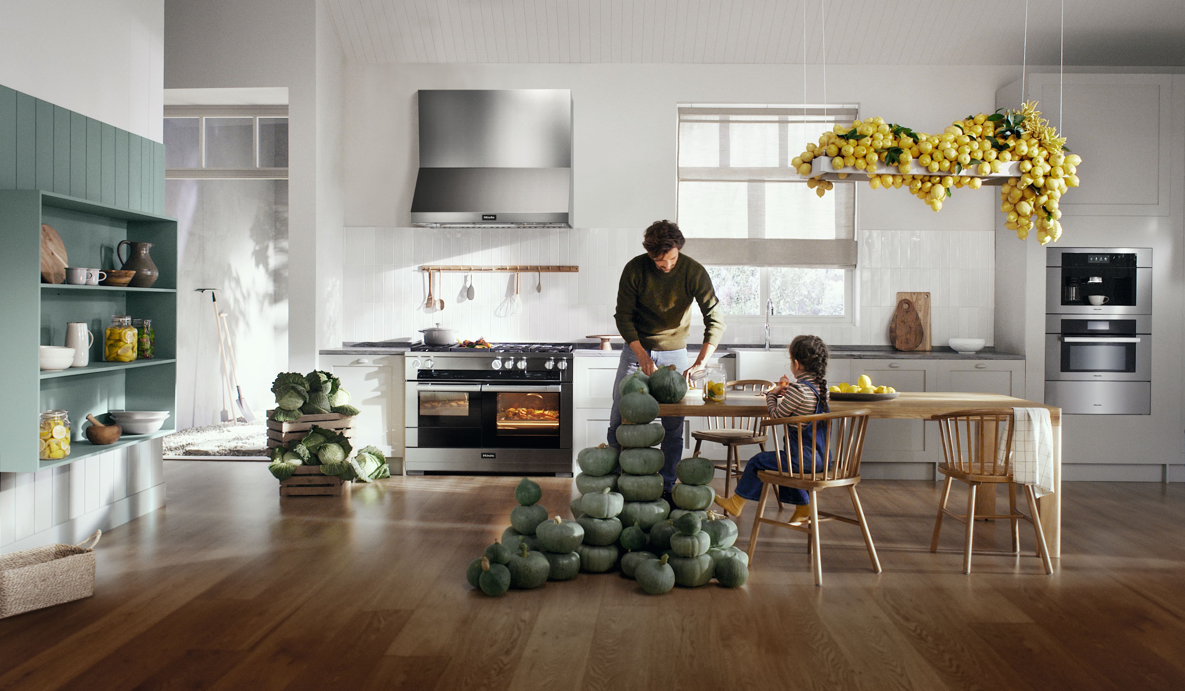 Bright modern kitchen with stainless range and built-in coffee station, pumpkins stacked, lemons overhead. Bright modern kitchen with stainless range and built-in coffee station, pumpkins stacked, lemons overhead.