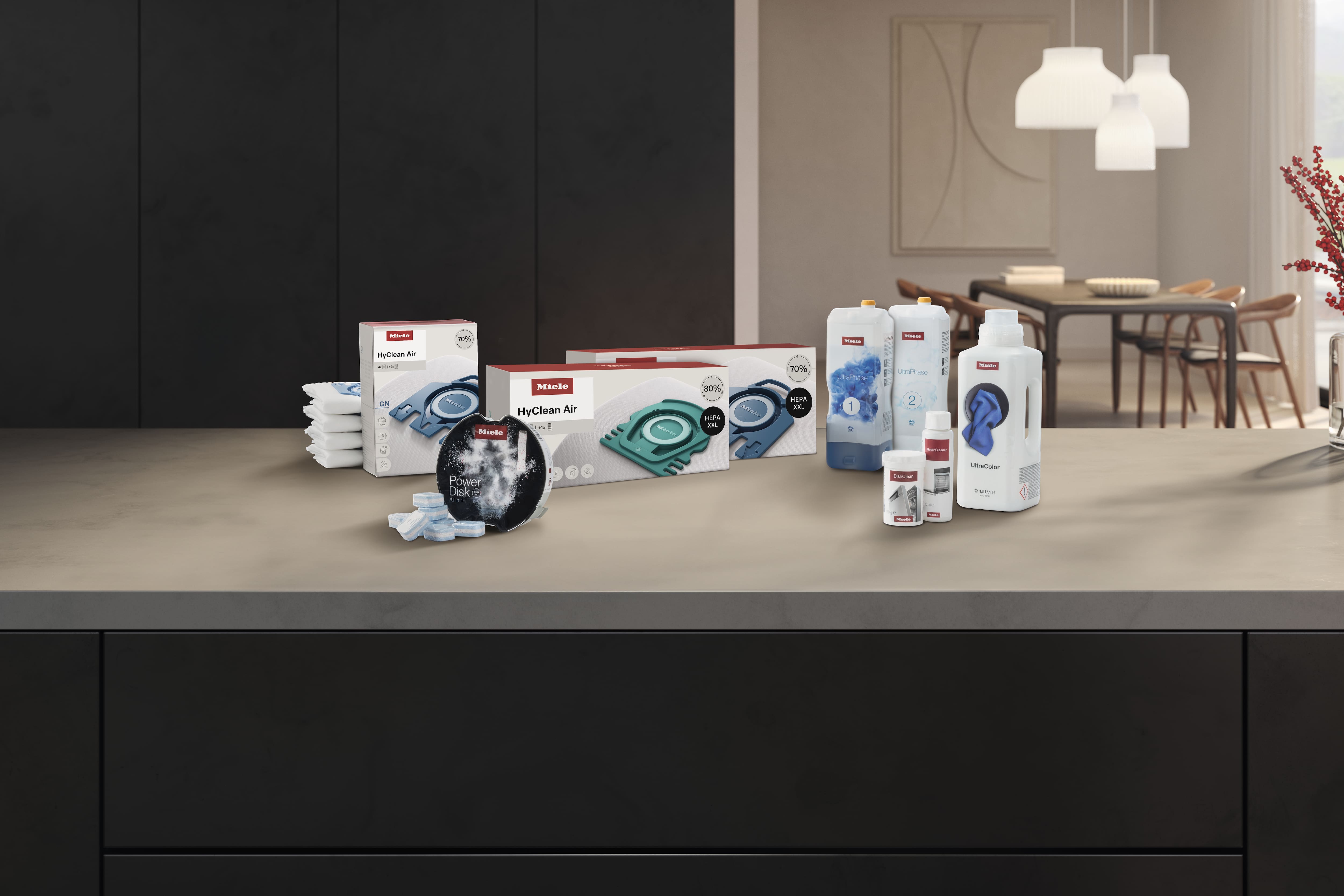 Assorted Miele cleaning and appliance consumables displayed on a kitchen counter in a modern home.