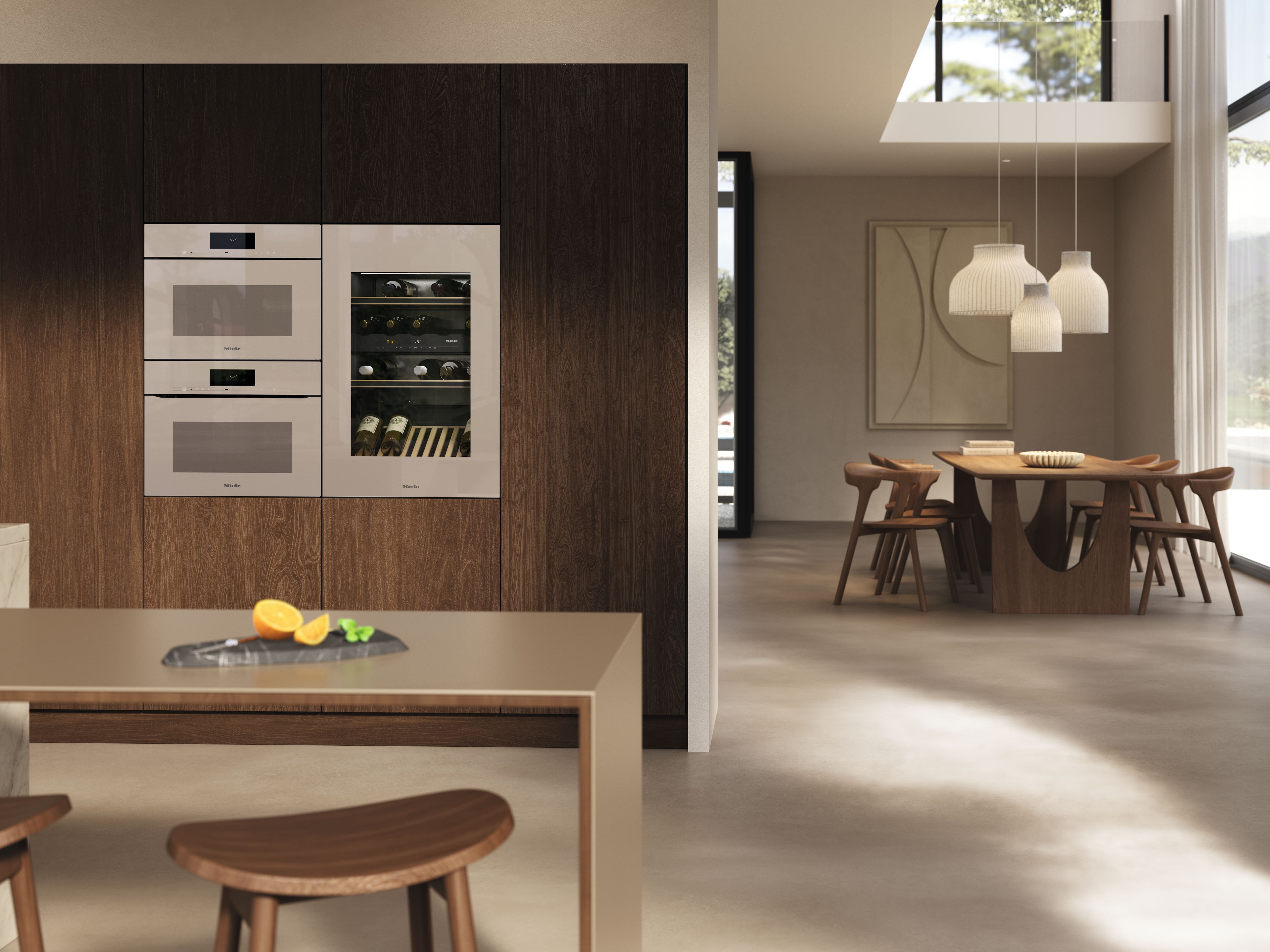 Moderne keuken-eetruimte met houten kasten, ingebouwde ovens en wijnkoeler, hanglampen boven de eettafel.