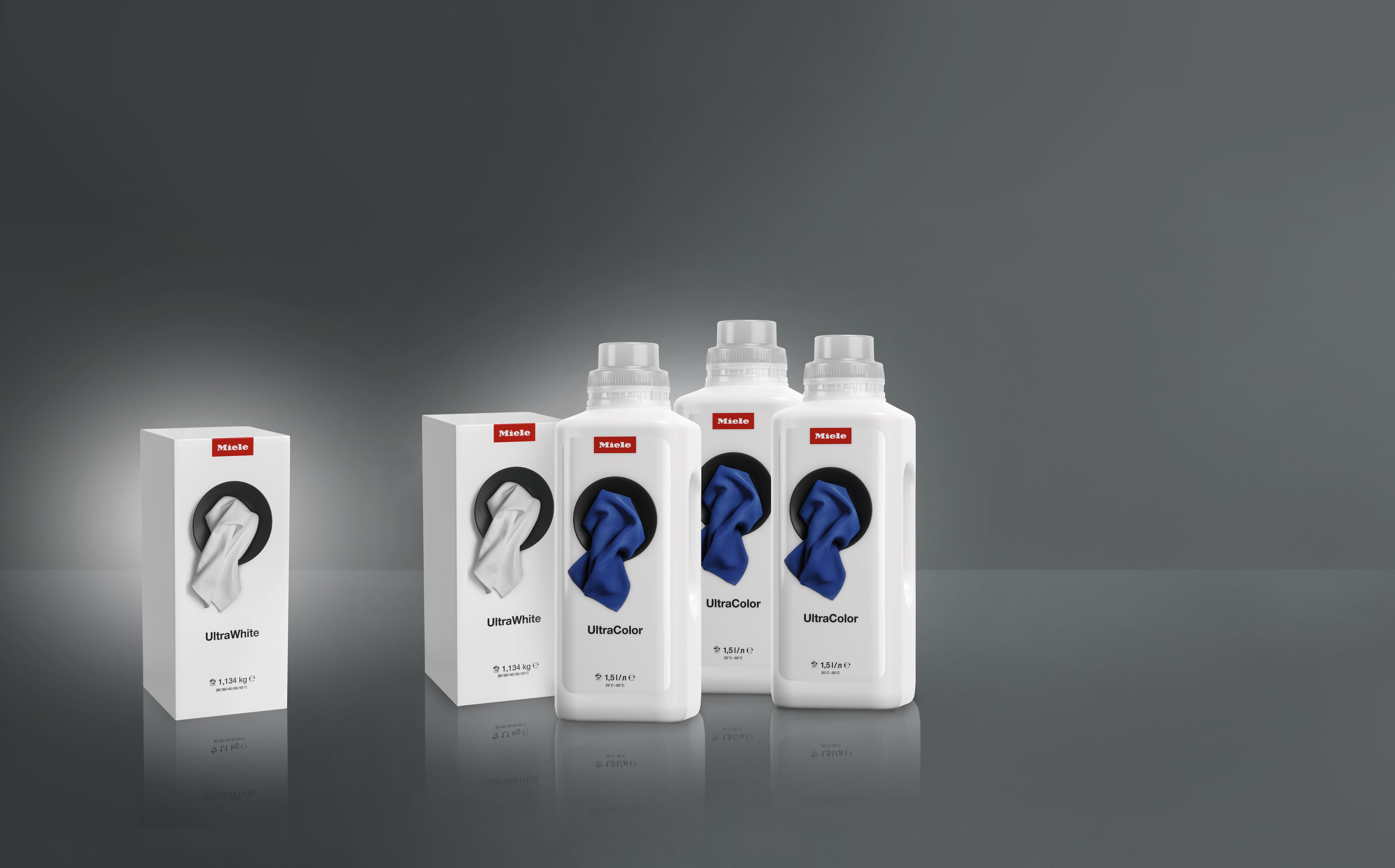 Product shot of Miele UltraWhite and UltraColor laundry detergents, boxes and bottles arranged on a gray studio background. Product shot of Miele UltraWhite and UltraColor laundry detergents, boxes and bottles arranged on a gray studio background.