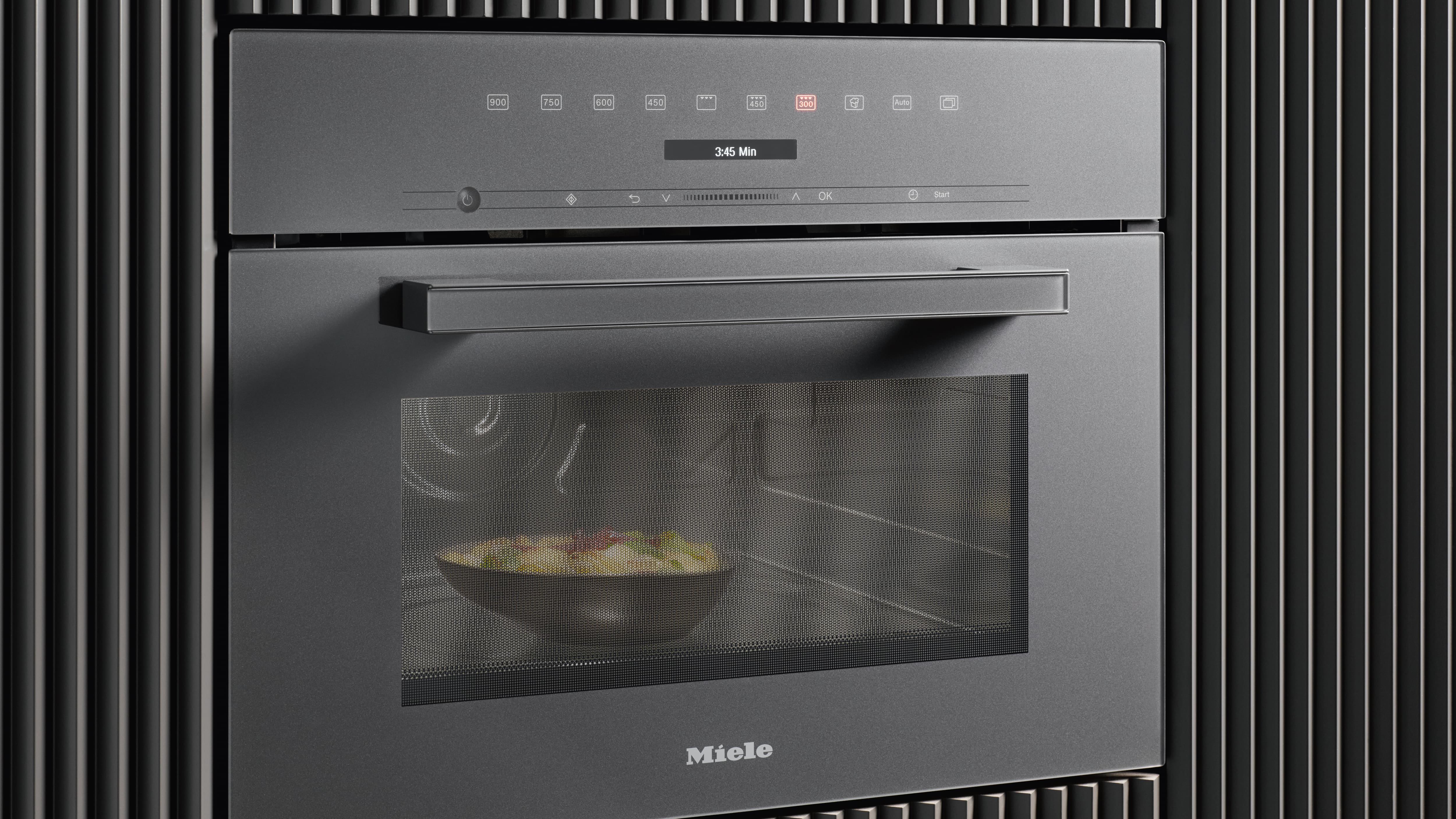 Miele mikrobølgeovn med en tallerken med mat på Miele mikrobølgeovn med en tallerken med mat på