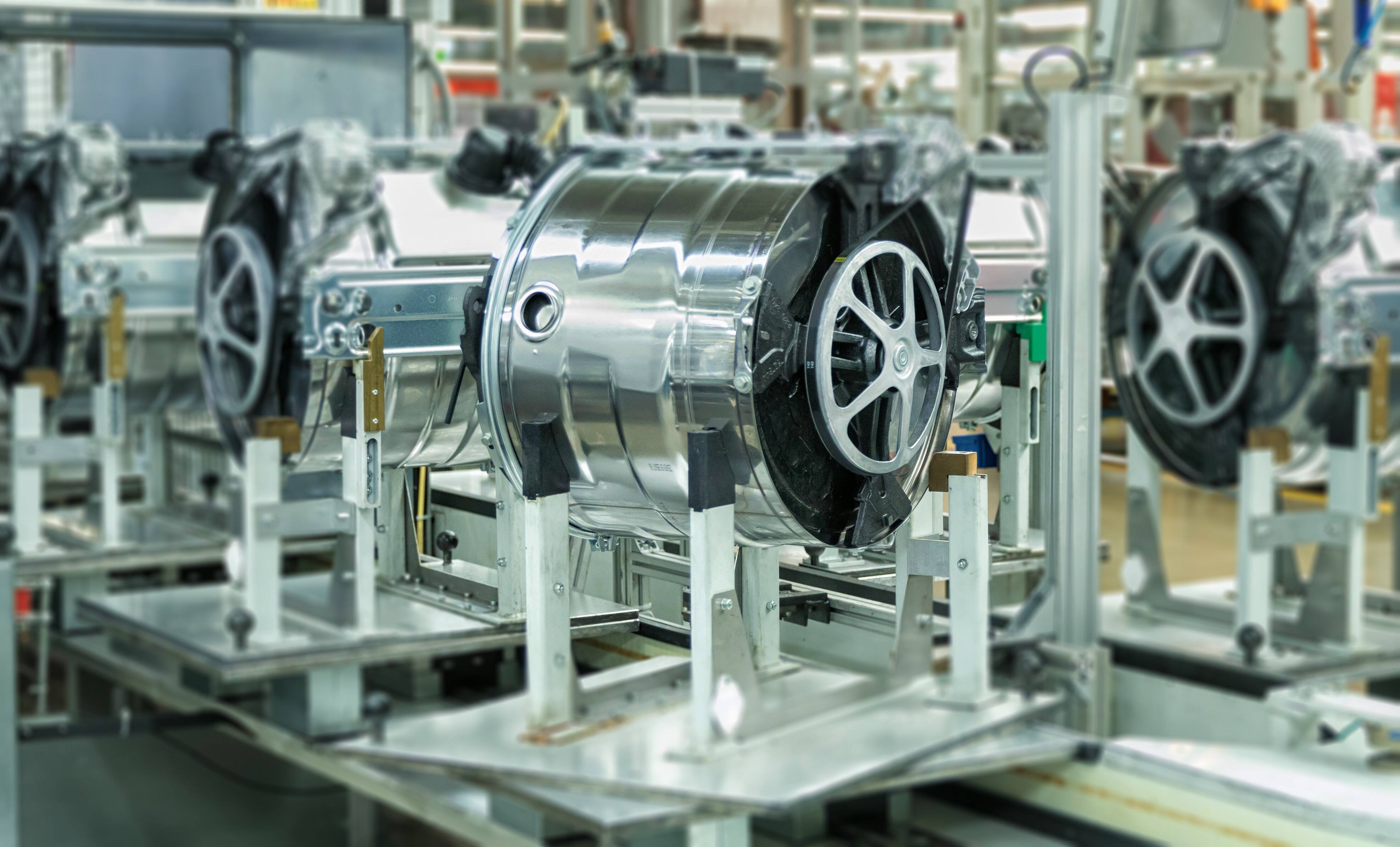 Stainless steel washing machine drums inside the Miele factory on a production lane Stainless steel washing machine drums inside the Miele factory on a production lane