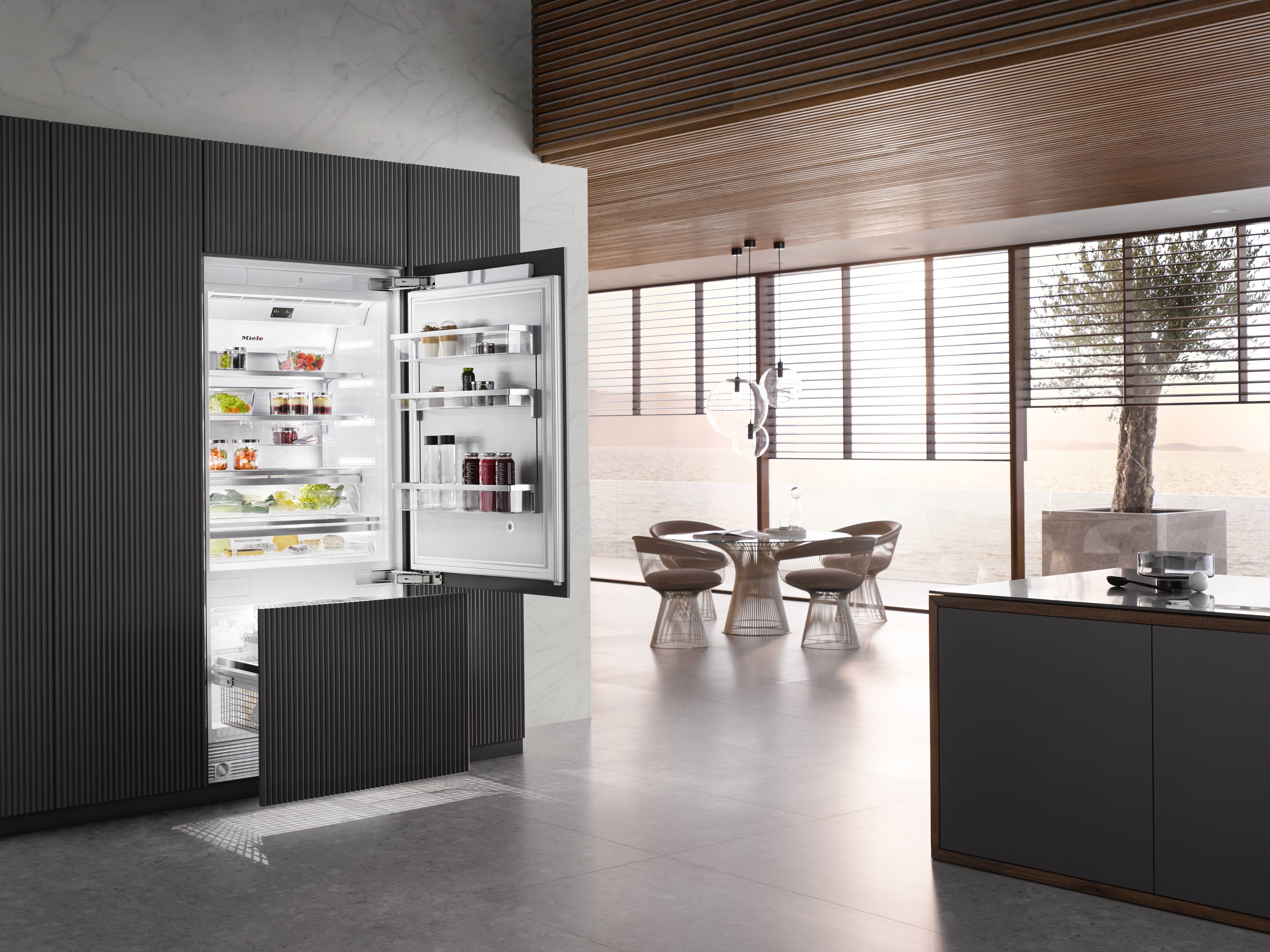 Cozinha moderna e elegante, com geladeira embutida, ilha e área para refeições, ao lado de grandes janelas com vista para o mar. Cozinha moderna e elegante, com geladeira embutida, ilha e área para refeições, ao lado de grandes janelas com vista para o mar.