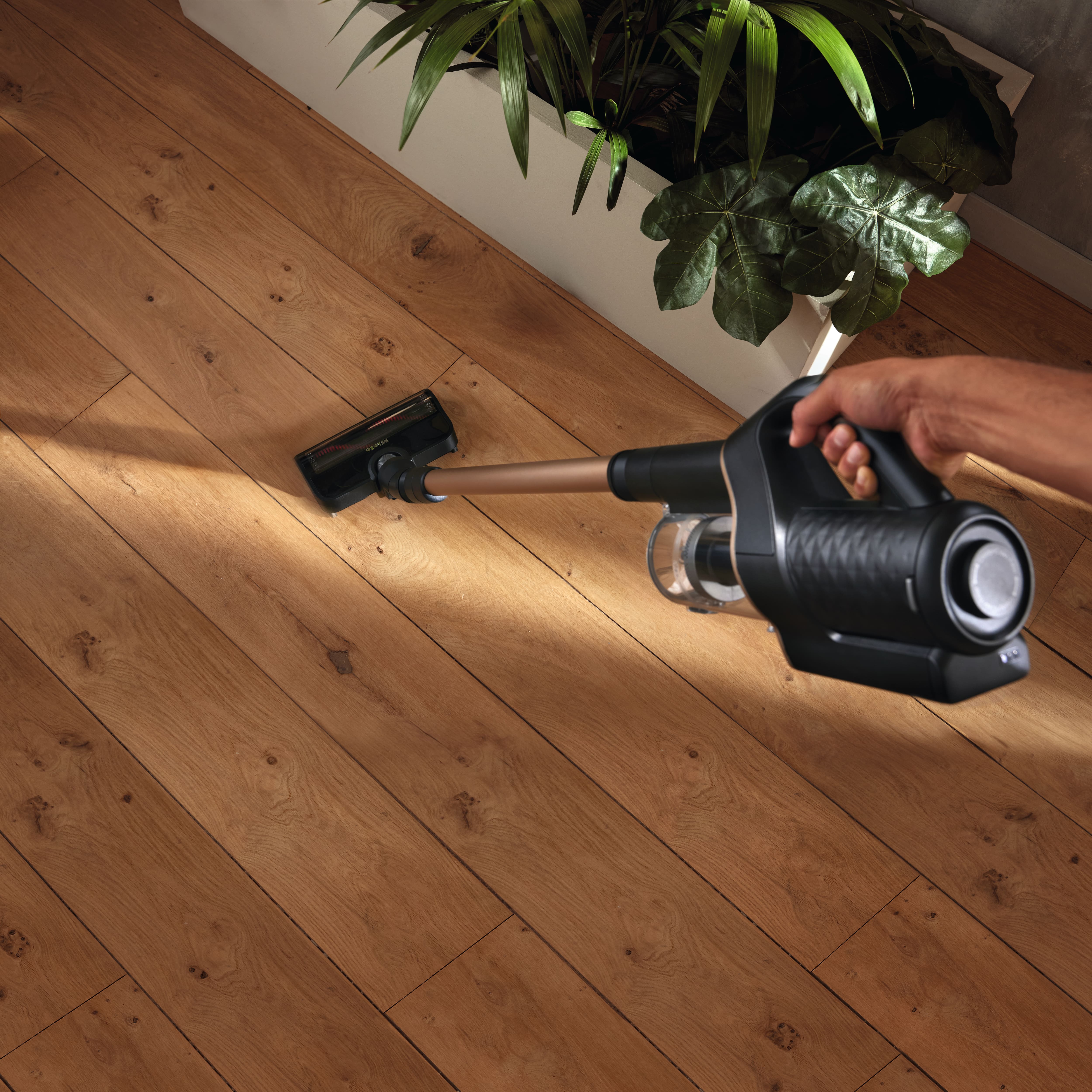 Miele cordless vacuum being held and used on hard floor