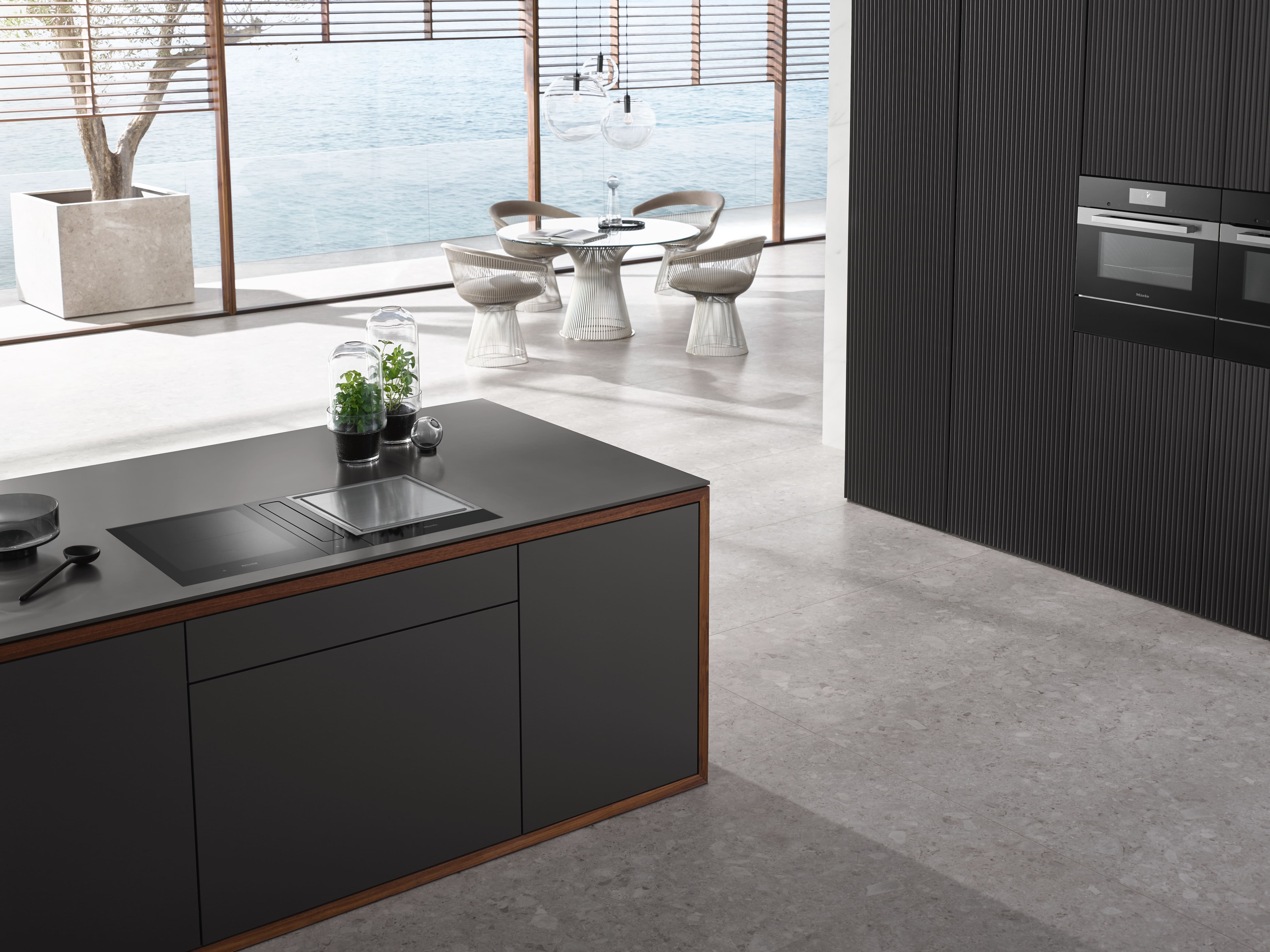 Modern kitchen island with integrated gas and induction cooktops, teppan grill, and pot steaming. Modern kitchen island with integrated gas and induction cooktops, teppan grill, and pot steaming.
