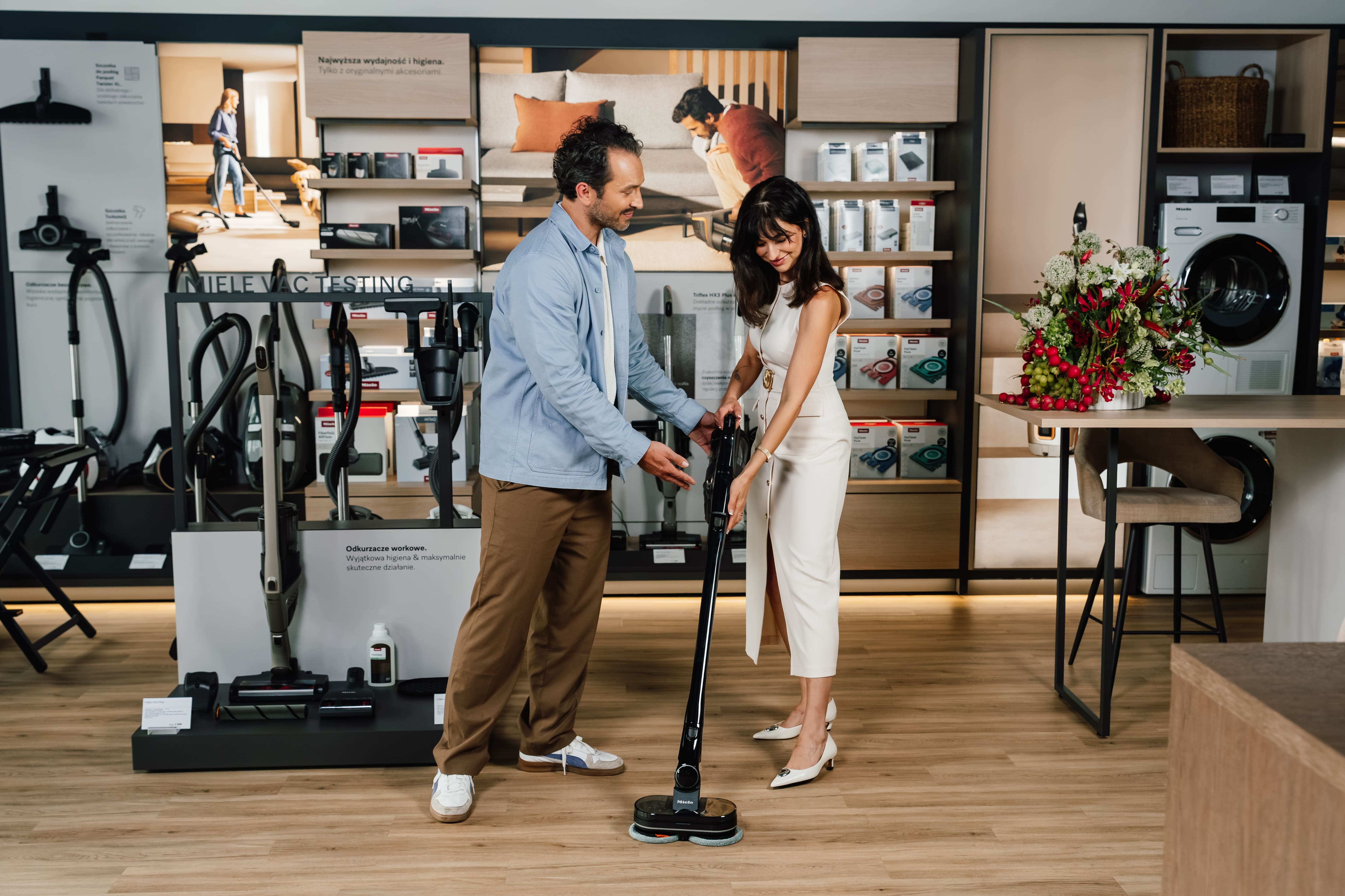 Uomo e donna con aspirapolvere Miele