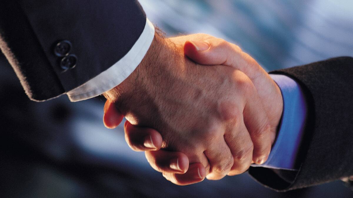 Primer plano de un apretón de manos entre dos hombres con traje de negocios