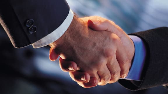 Close-up of a handshake between two men in business suits