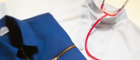 Pracovní oděvy – montérky a bílý lékařský plášť.