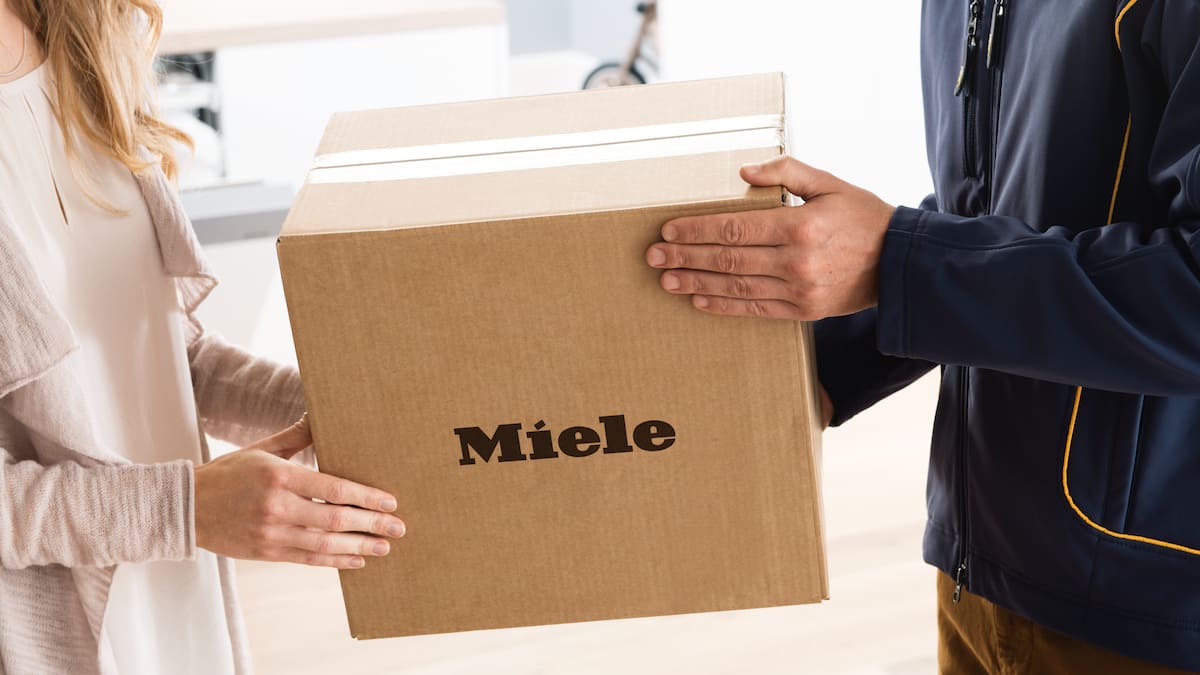 Postbode overhandigt pakket met onderdelen aan vrouwelijke ontvanger