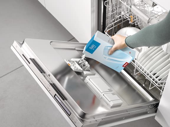 Fyldning af en Miele Professional-erhvervsopvaskemaskine med salt