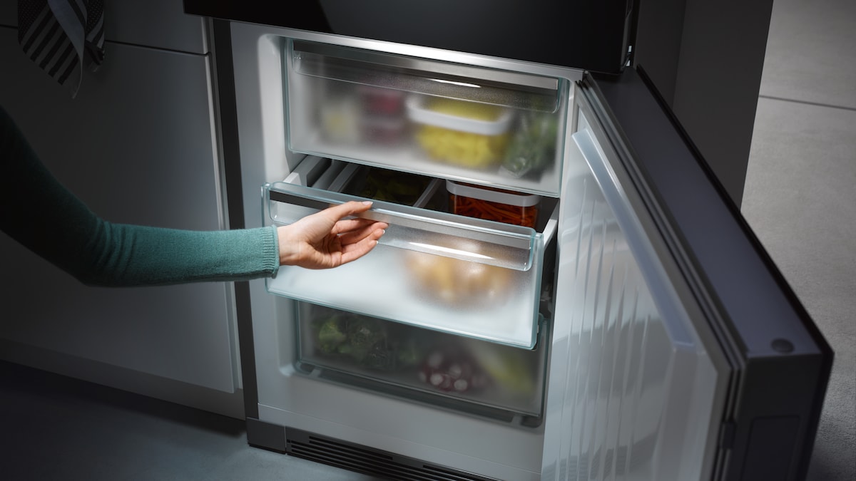 a hand opening a Miele freezer