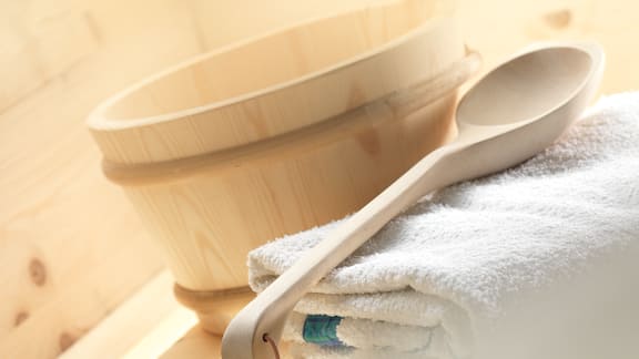White towel and wooden spoon in the sauna.
