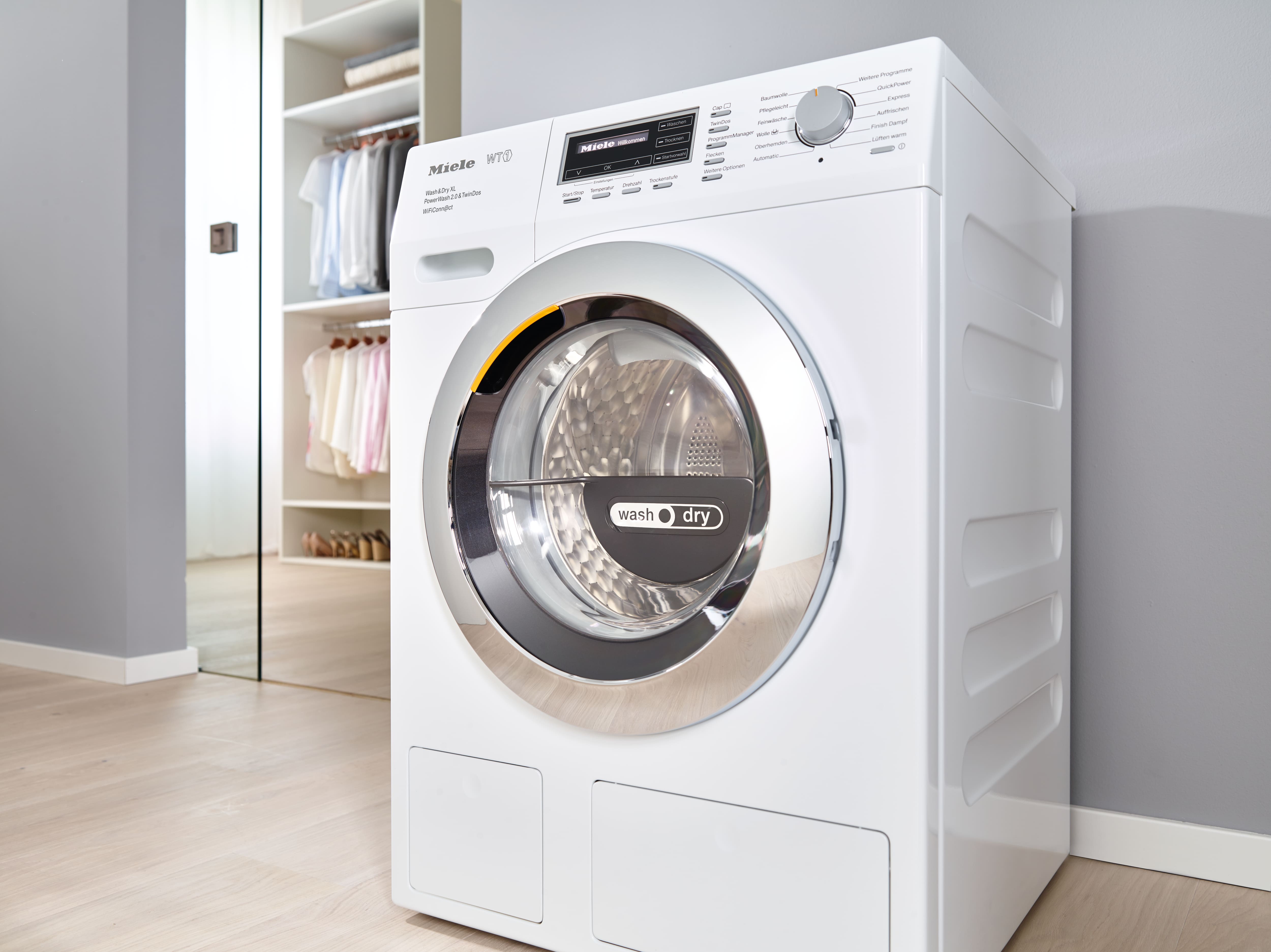 A Miele washer dryer next to a dressing room A Miele washer dryer next to a dressing room
