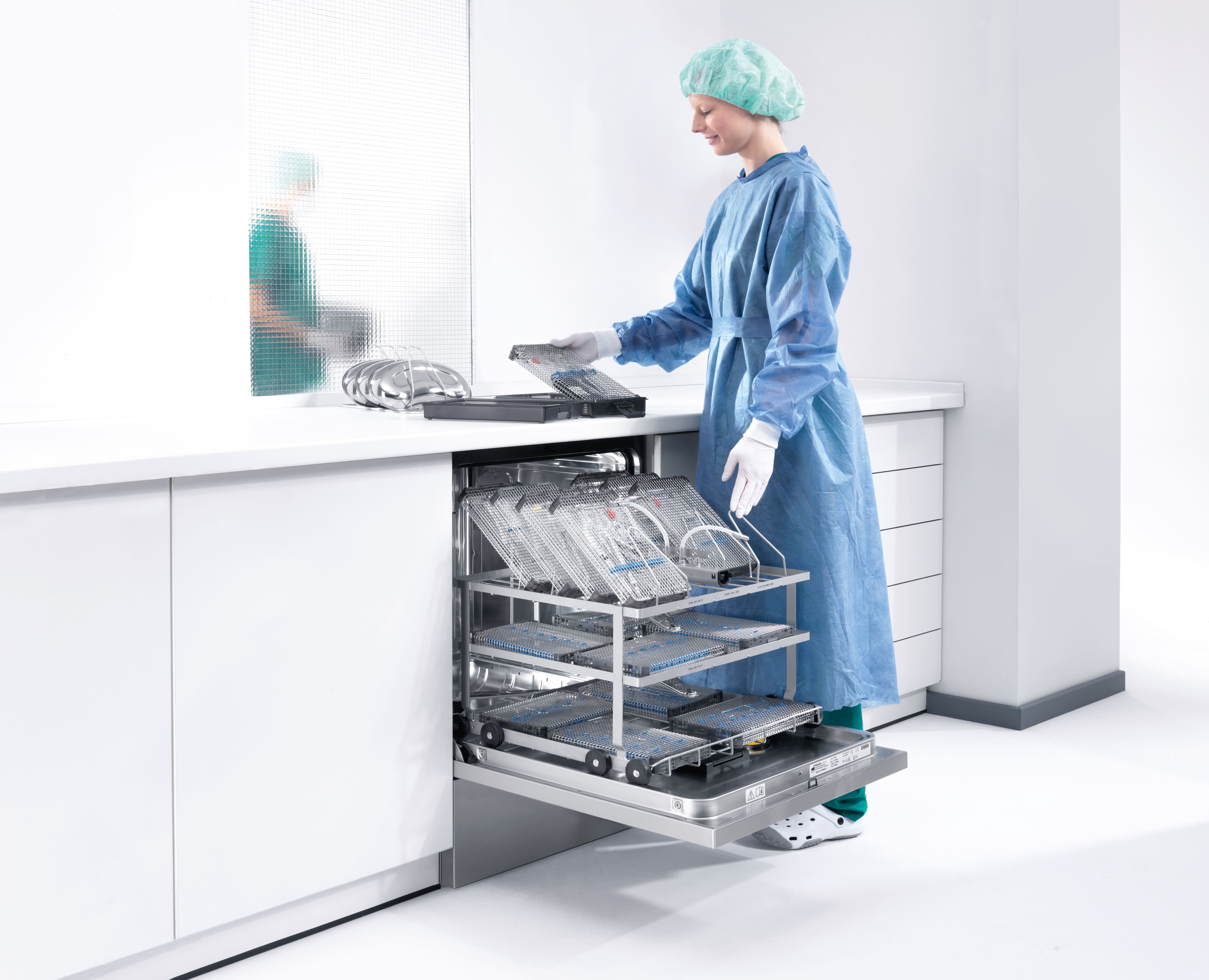 Doktersassistente staat bij een reinigings- en desinfectieapparaat