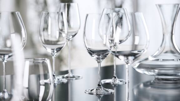 Différents types de verre accompagnés d’un décanteur sont posés sur une table.