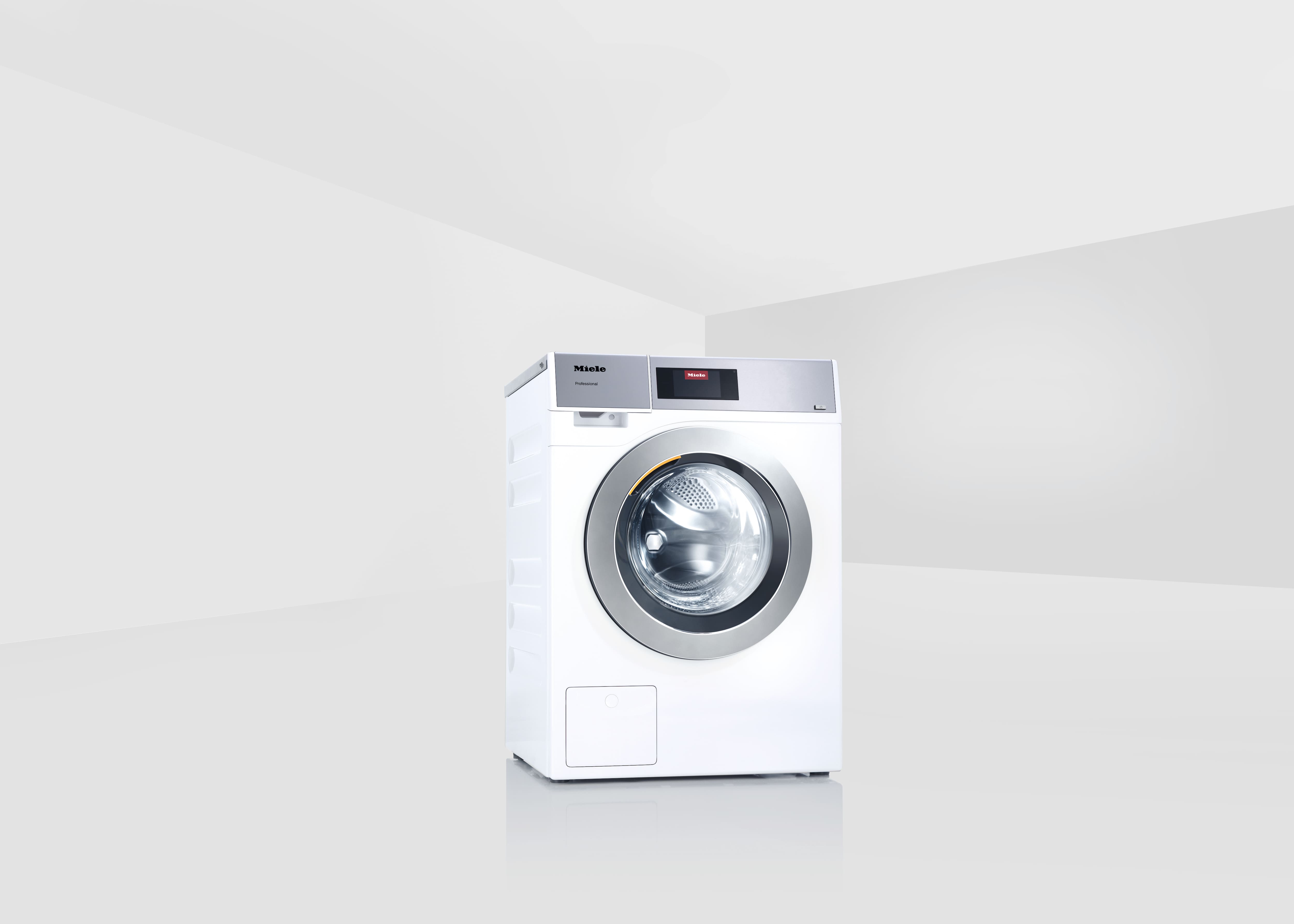 Freistehende Miele Professional Frontlader-Waschmaschine PWM 906/PWM 907/PWM 908 in Lotosweiß in einem minimalistischen, hellen Raum.