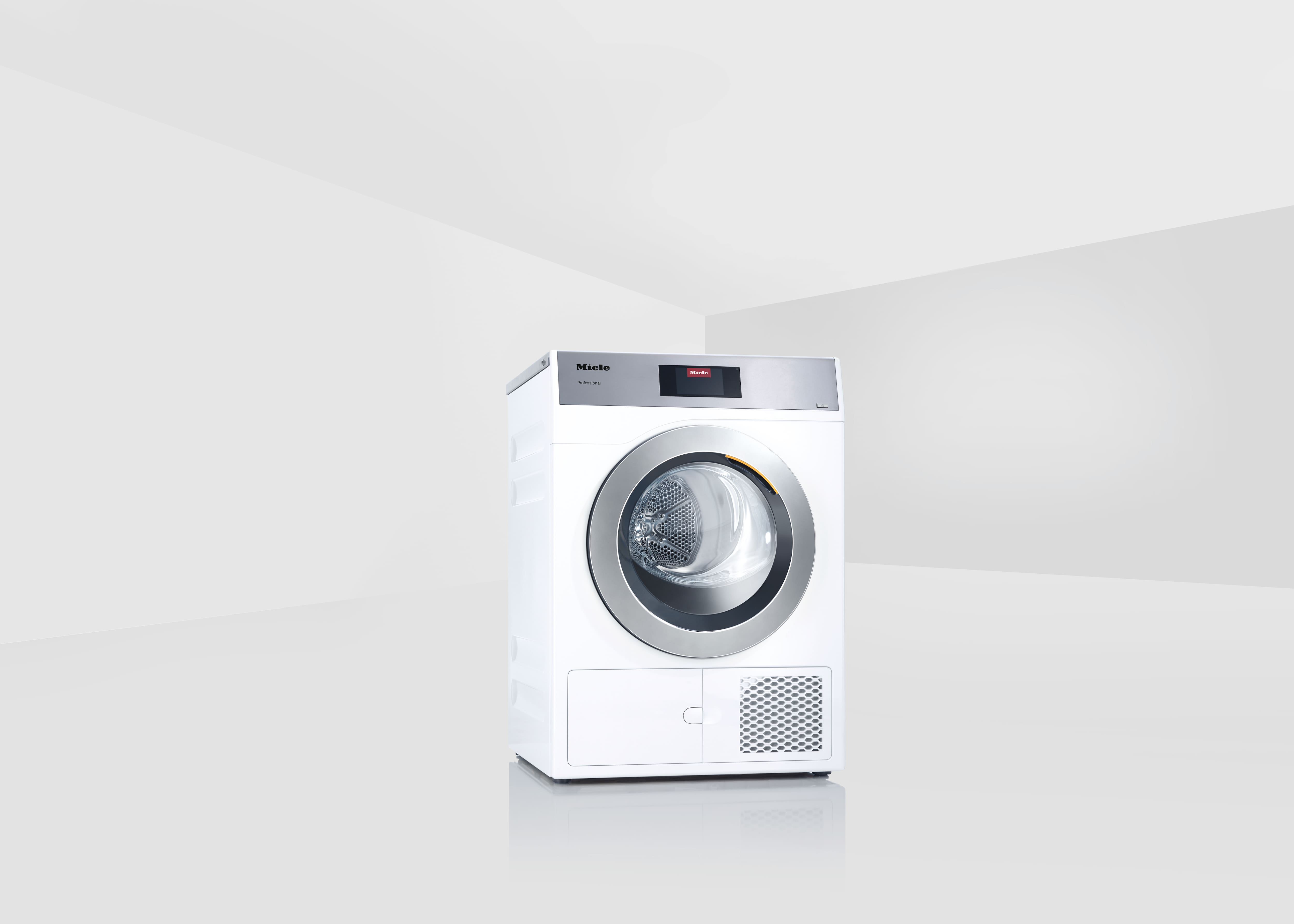 Freistehender Miele Professional Wäschetrockner PDR 908 HPP in Lotosweiß in einem minimalistischen, hellen Raum.