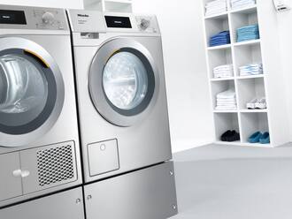 Waschmaschine und Trockner in Edelstahl in einem Hauswirtschaftsraum einer Praxis.