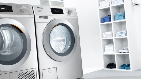 Een Miele wasmachine en droger in de wasruimte van een praktijk