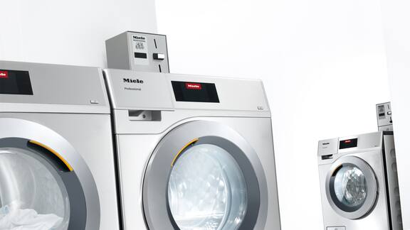Profesionella tvättmaskiner i rostfritt stål i minimalistisk omgivning.