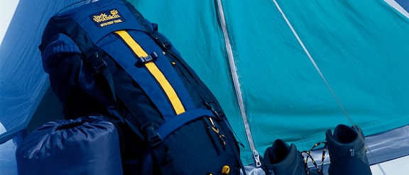 Sinisiä retkeilyvarusteita, kuten makuupussi, reppu ja teltta.