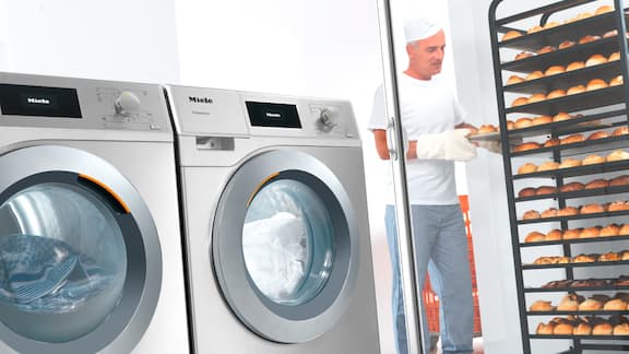 Wasmachine en droogkast staan in de bakkerij.