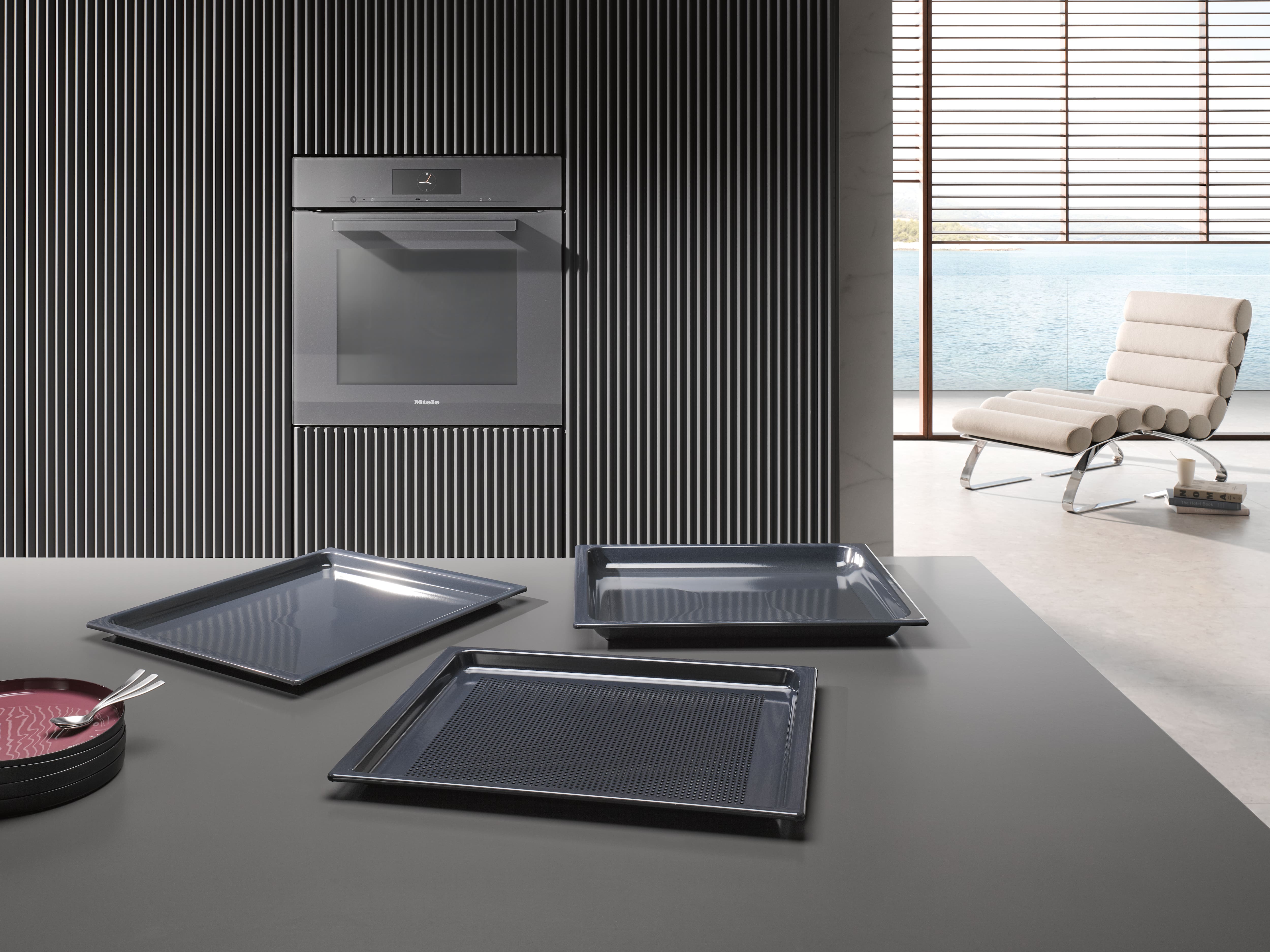 Front view of an oven, viewed from the surface of a kitchen aisle with three grey trays