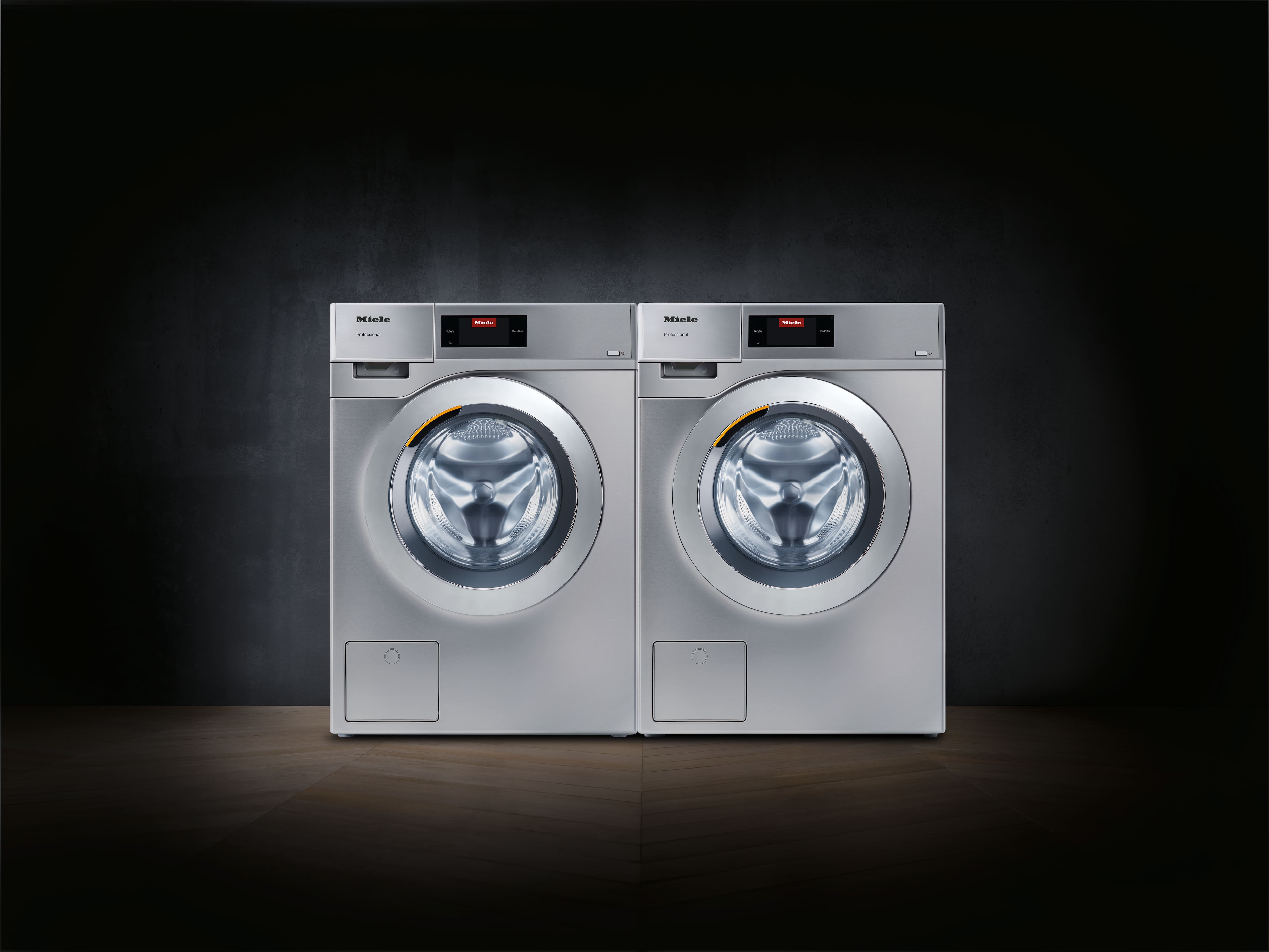 Washing Machine and Dryer situated in a shadowy room, highlighting their modern features in low light.